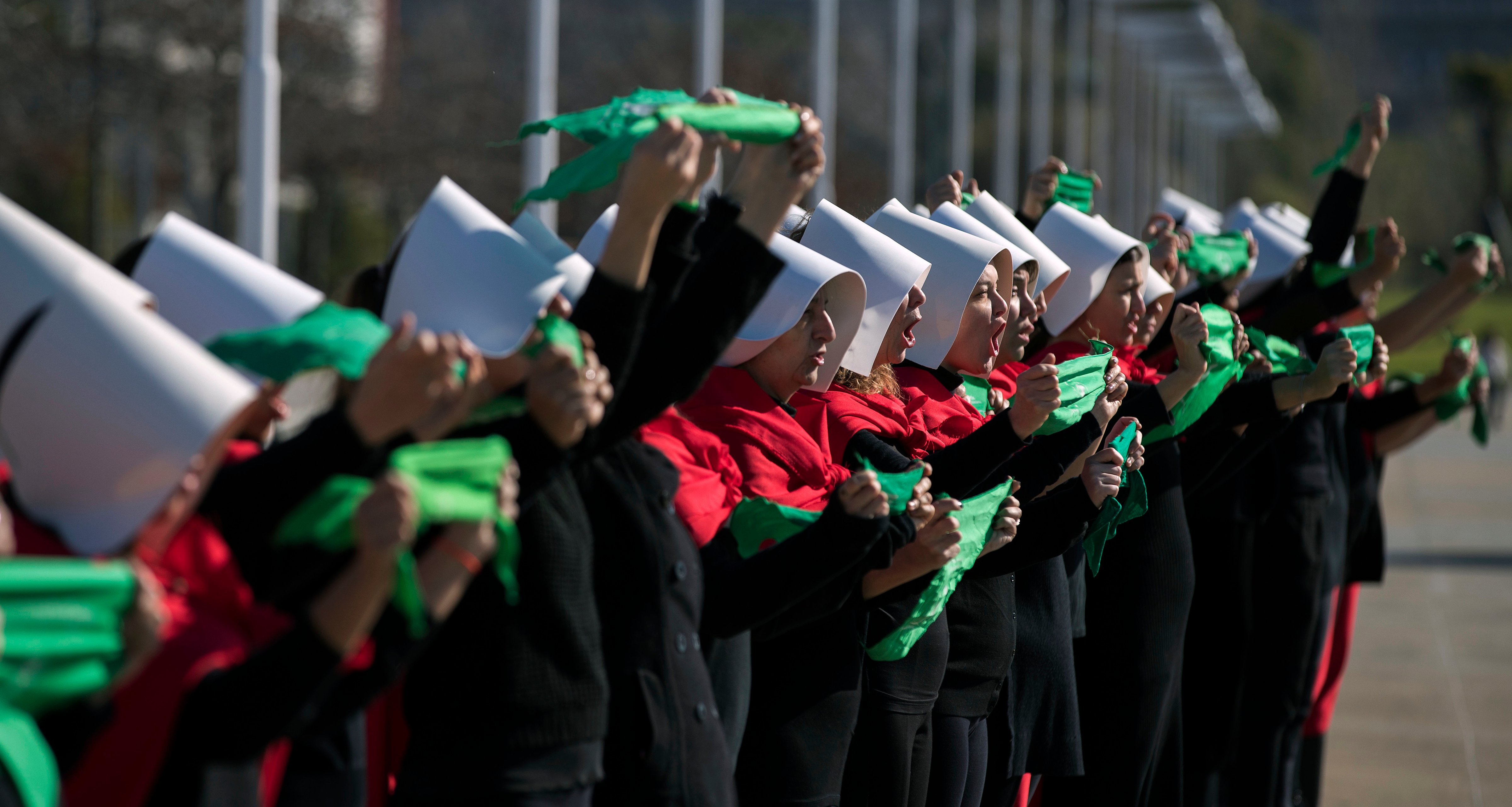 Activists in favour of the legalization of abortion disguised as characters from Canadian author Margaret Atwood's feminist dystopian novel "The Handmaid's Tale,"  display green headscarves as they perform at the "Parque de la Memoria" (Remembrance Park) in Buenos Aires, on August 5, 2018. (Alejandro Pagni—AFP/Getty Images)