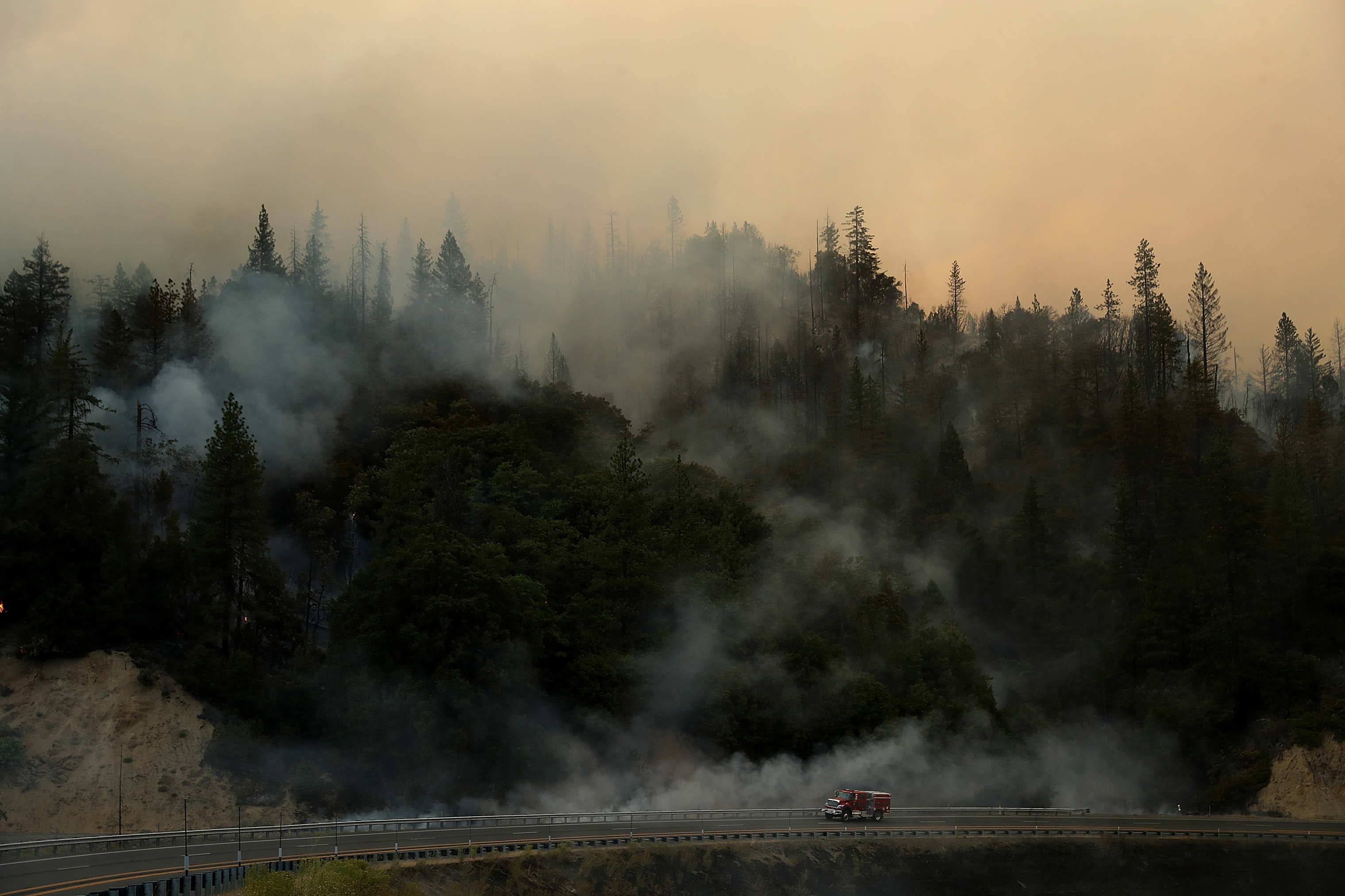 A Cal Fire truck drives along highway 299 as the Carr Fire burns in the hills near Whiskeytown, Calif. on July 28. (Justin Sullivan—Getty Images)