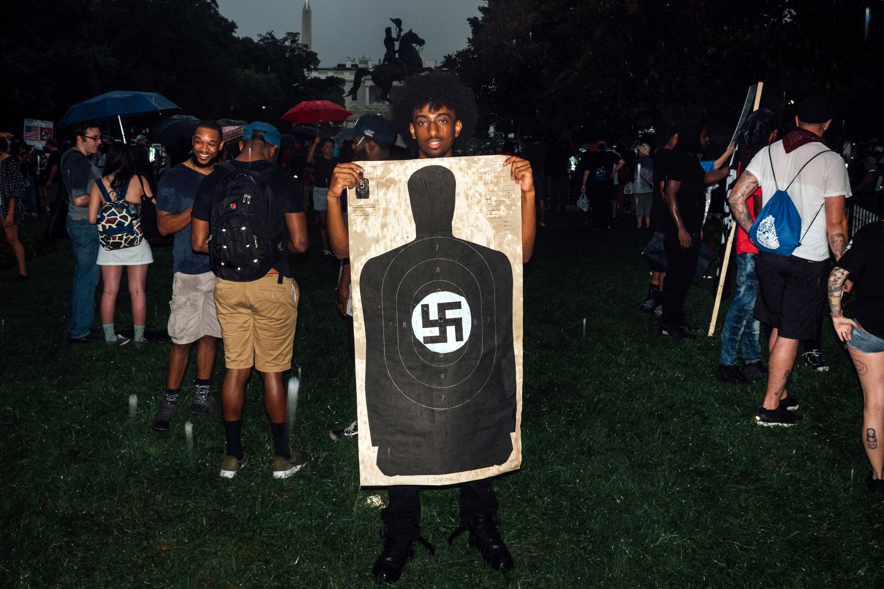 A counter-protester holds a shooting target with a swastika in the middle. (Daniel Arnold for TIME)