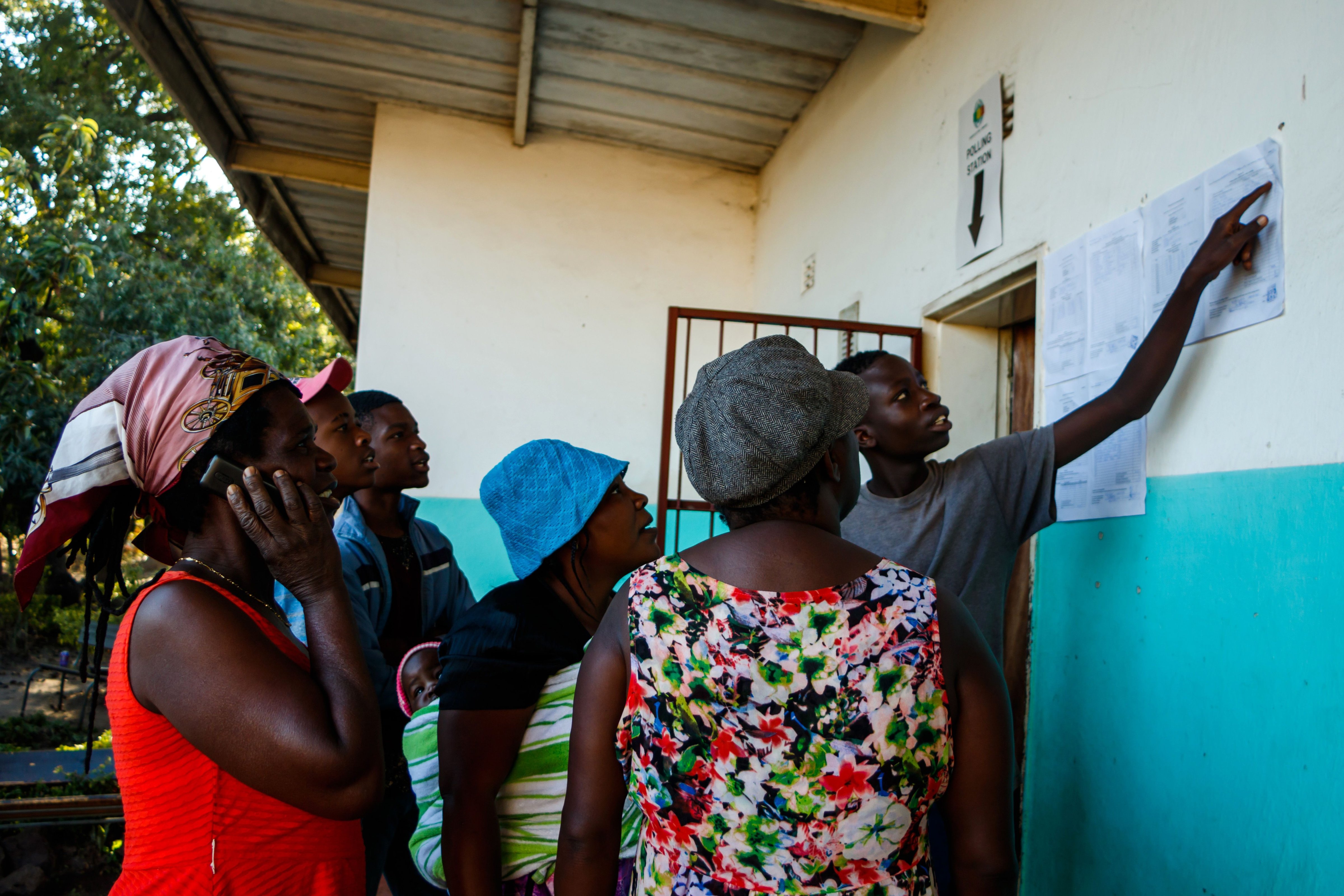 People gather a day after elections to look at results posted outside a polling station in Harare, Zimbabwe on July 31 2018. (Jekesai Nijikizana—AFP/Getty Images)