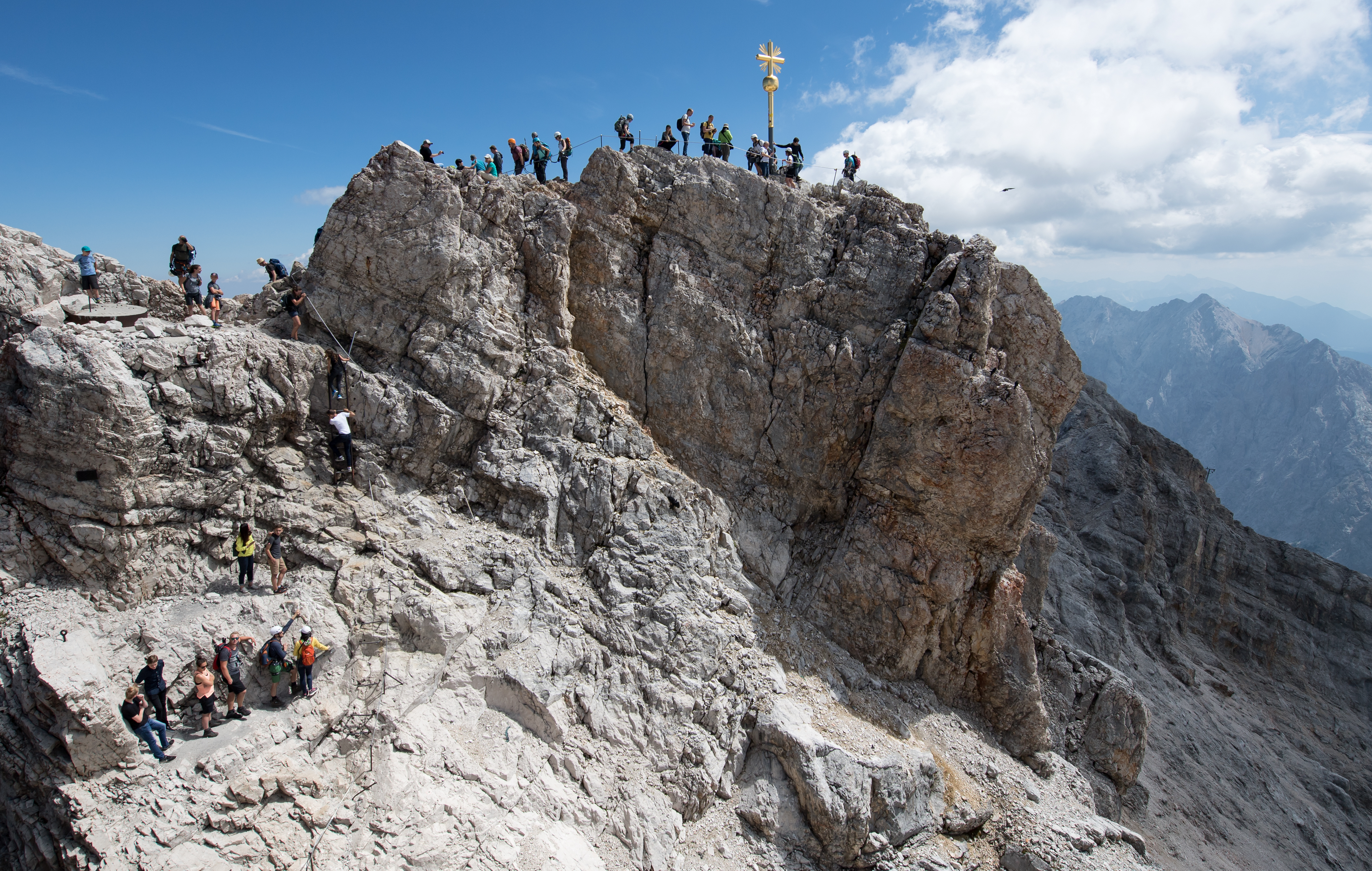 Numerous excursionists use the beautiful weather for an excursion to the summit cross on the Zugspitze. (Sven Hoppe—picture alliance/Getty Images)