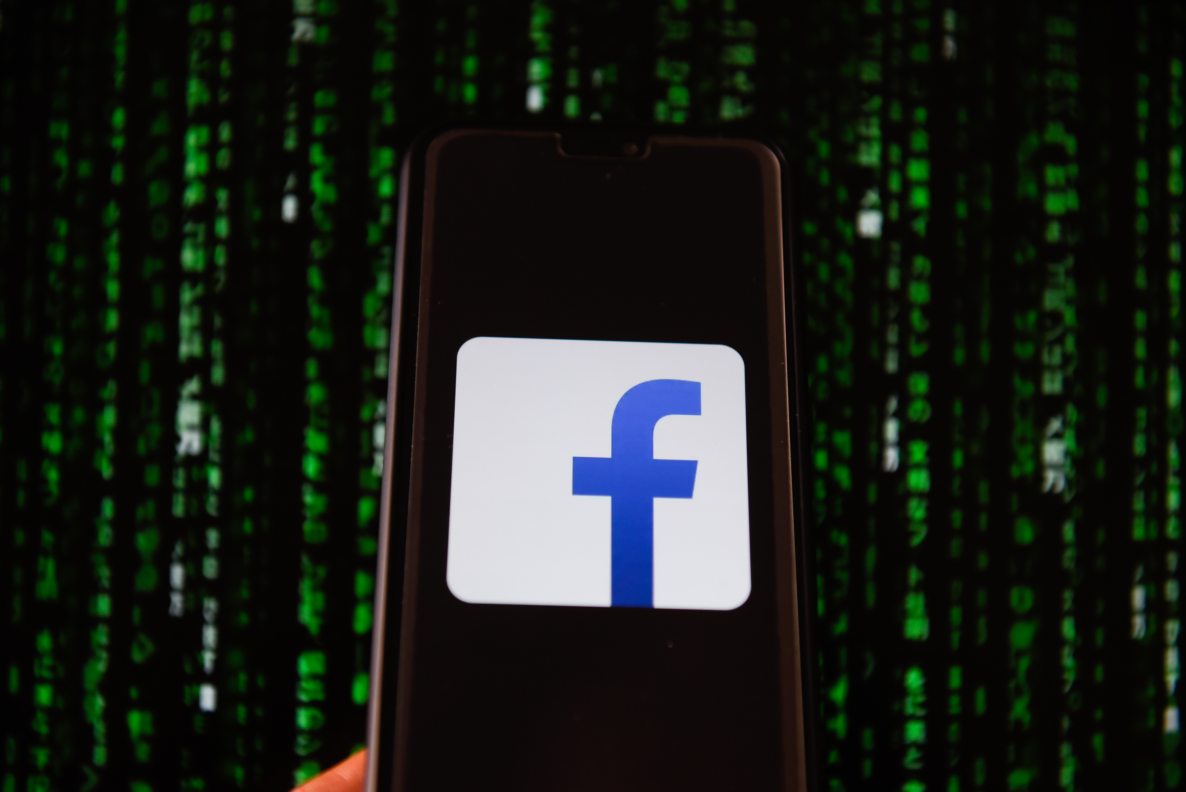 Facebook logo is seen on a mobile phone