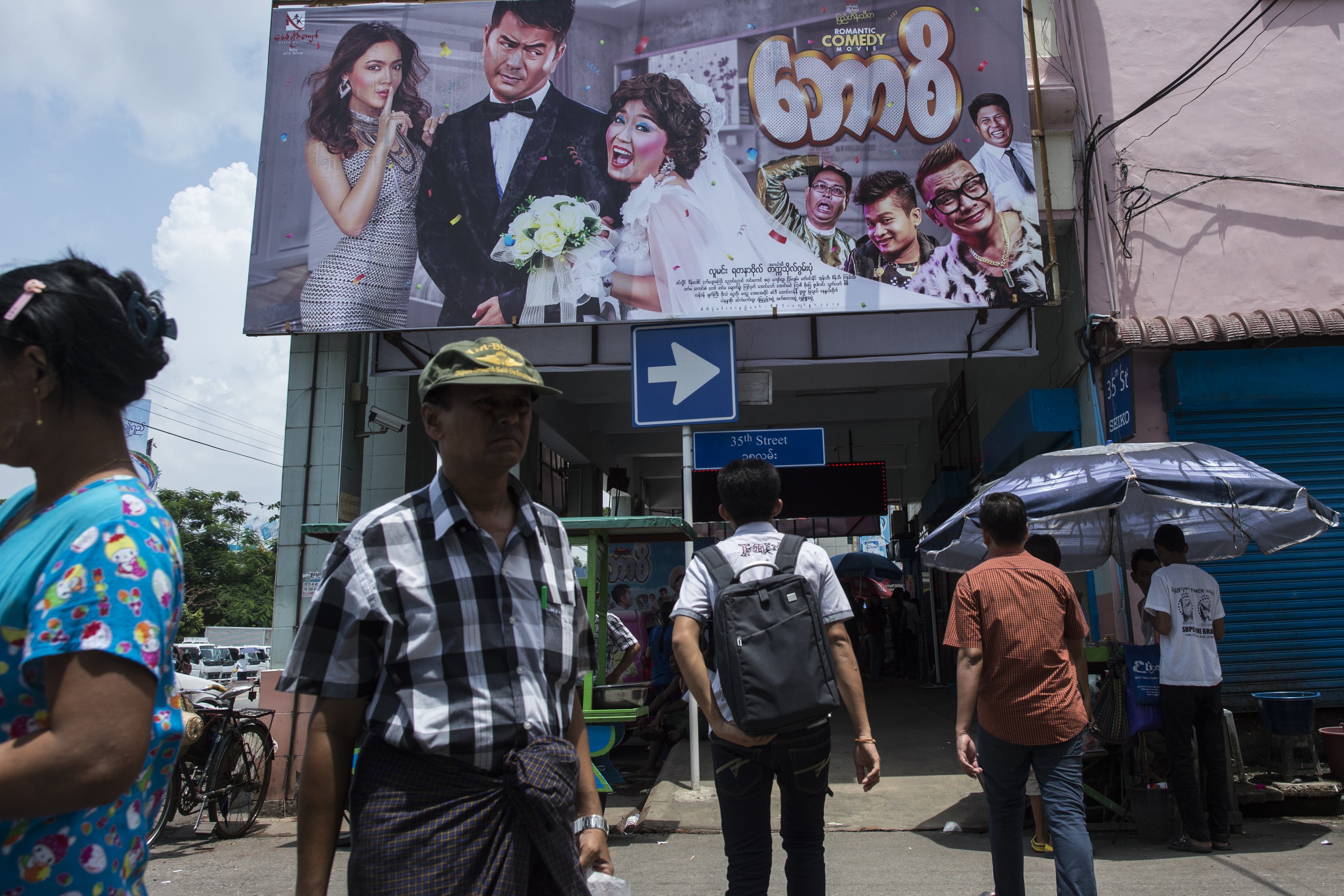 This picture taken on August 22, 2016, shows people walking by the Thwin cinema in downtown area of Yangon. (YE AUNG THU—AFP/Getty Images)