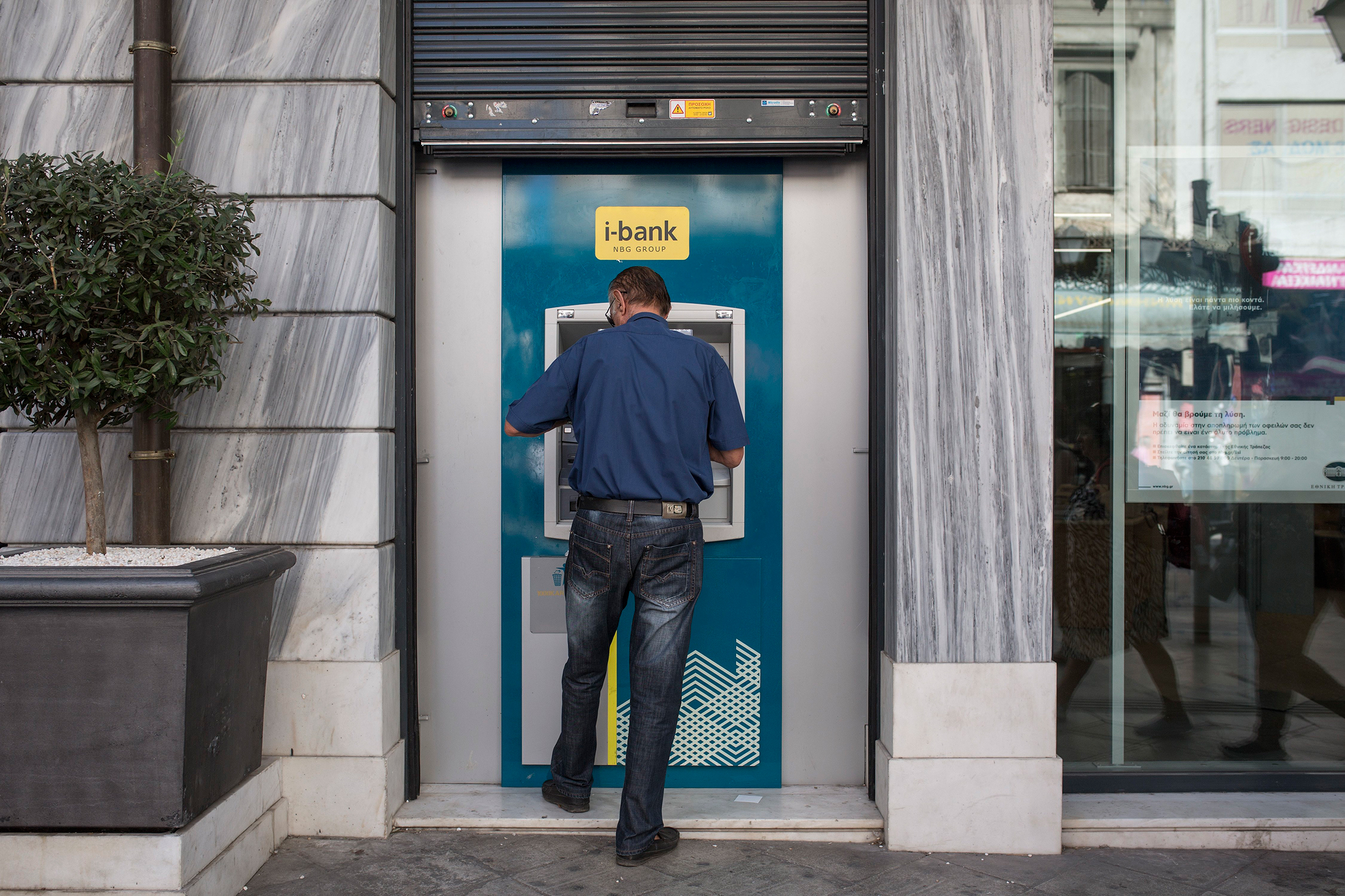 A man stands at an ATM in Athens. On Aug. 20, the last bailout program for Greece came to an end (Socrates Baltagiannis—Picture-Alliance/DPA/AP)