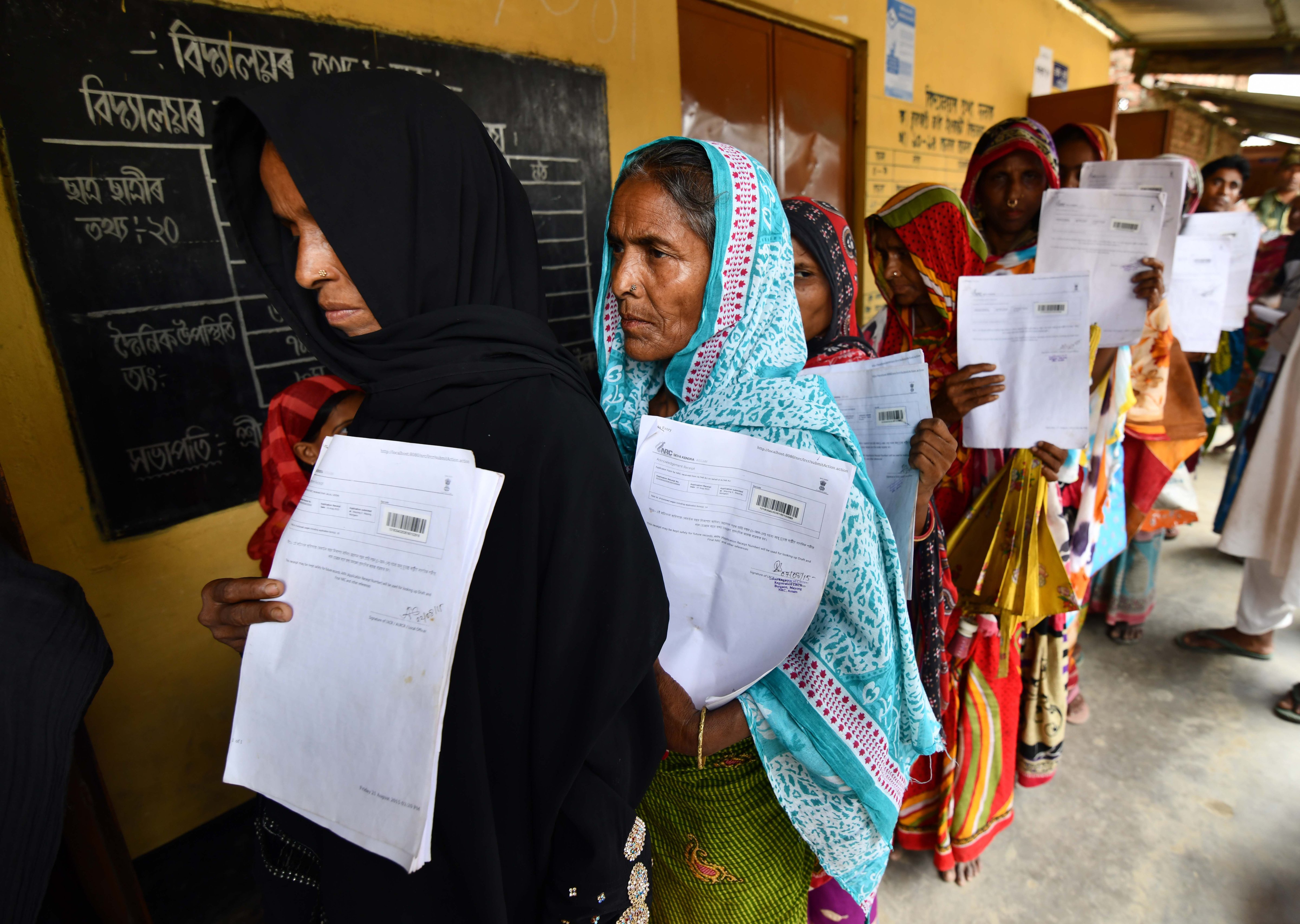 Residents hold their documents as they stand in a queue to check their names on the final list of National Register of Citizens (NRC) at a NRC Sewa Kendra (NSK) in Burgoan village in Morigoan district on July 30, 2018. (Biju Boro—AFP/Getty Images)