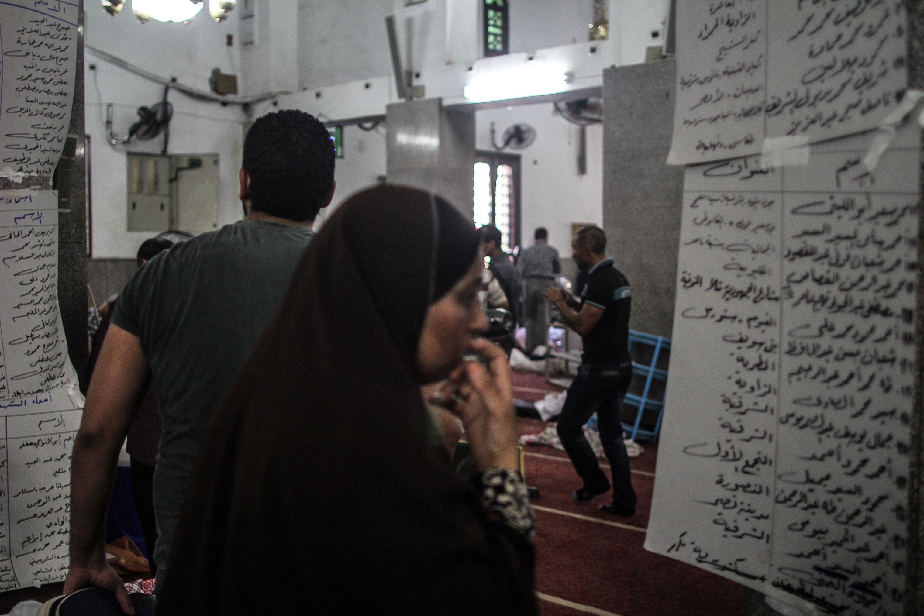The next day, at a mosque where the bodies were transferred, a distraught mother searches for her son's name on a list showing who had been killed. (Mosa’ab Elshamy)