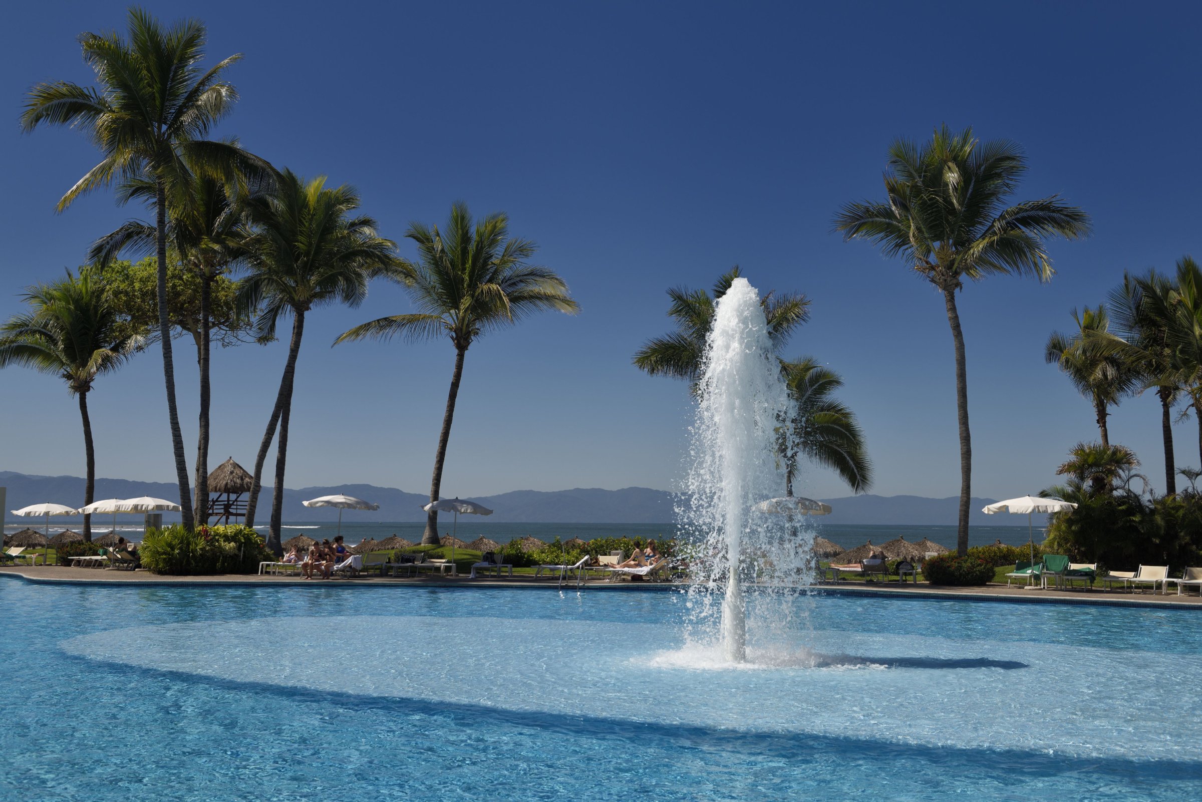 Pool with fountain at Nuevo Vallarta Mexico with Palm trees and vacationers