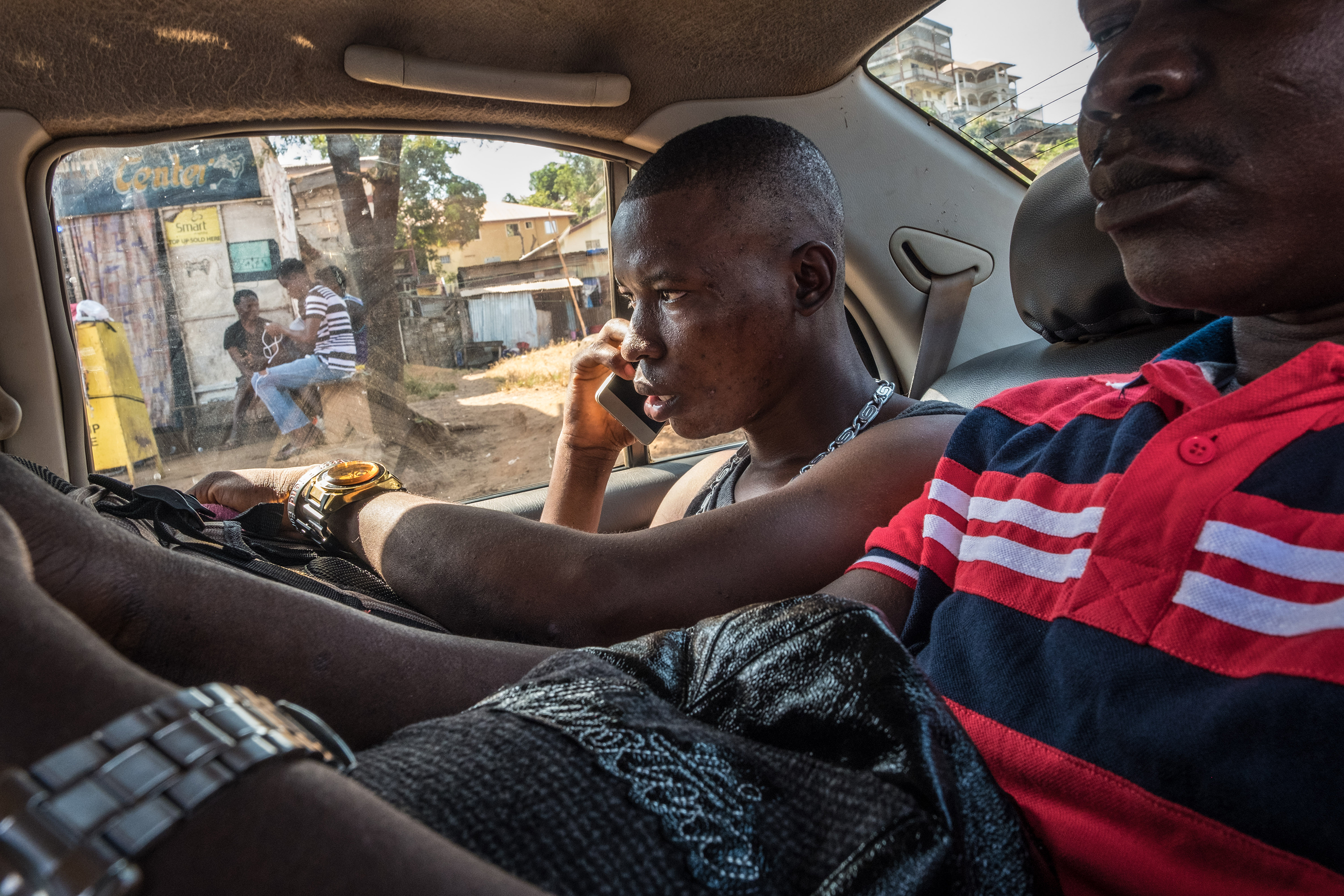 Johnbull, who decided to leave Sierra Leone to pursue an education abroad, travels with his uncle in a taxi to the ferry terminal on the morning of his departure to Ghana. (Tommy Trenchard—Panos for TIME)
