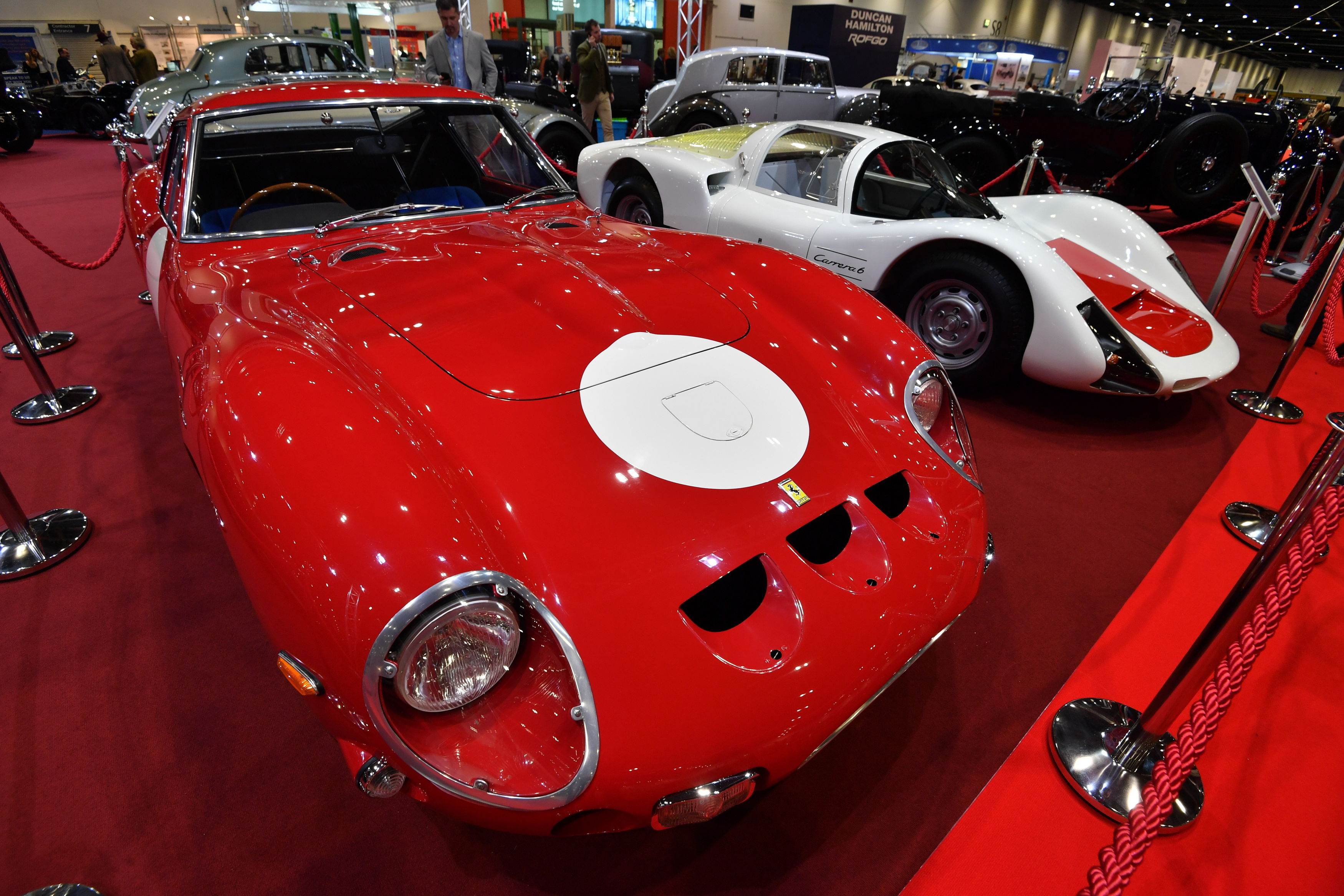 A red 1962 Ferrari 250 GTO (left) and a white 1966 Porsche 906 at the preview for the London Classic Car Show, at ExCeL in London on February 15, 2018. (John Stillwell—PA Wire—AP)