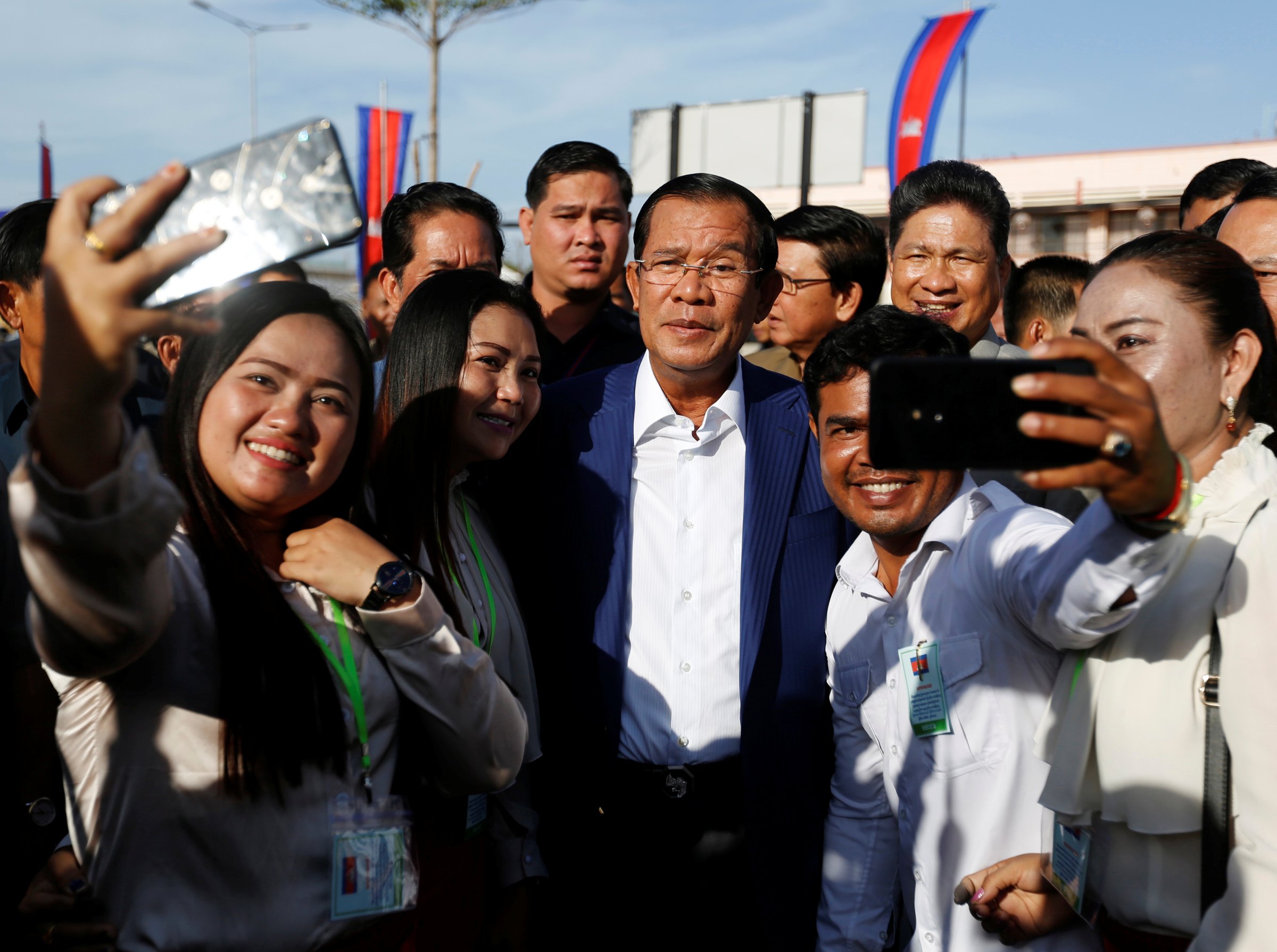 Supporters take pictures with Cambodia's Prime Minister Hun Sen as he attends an inauguration of a new boat terminal in Phnom Penh