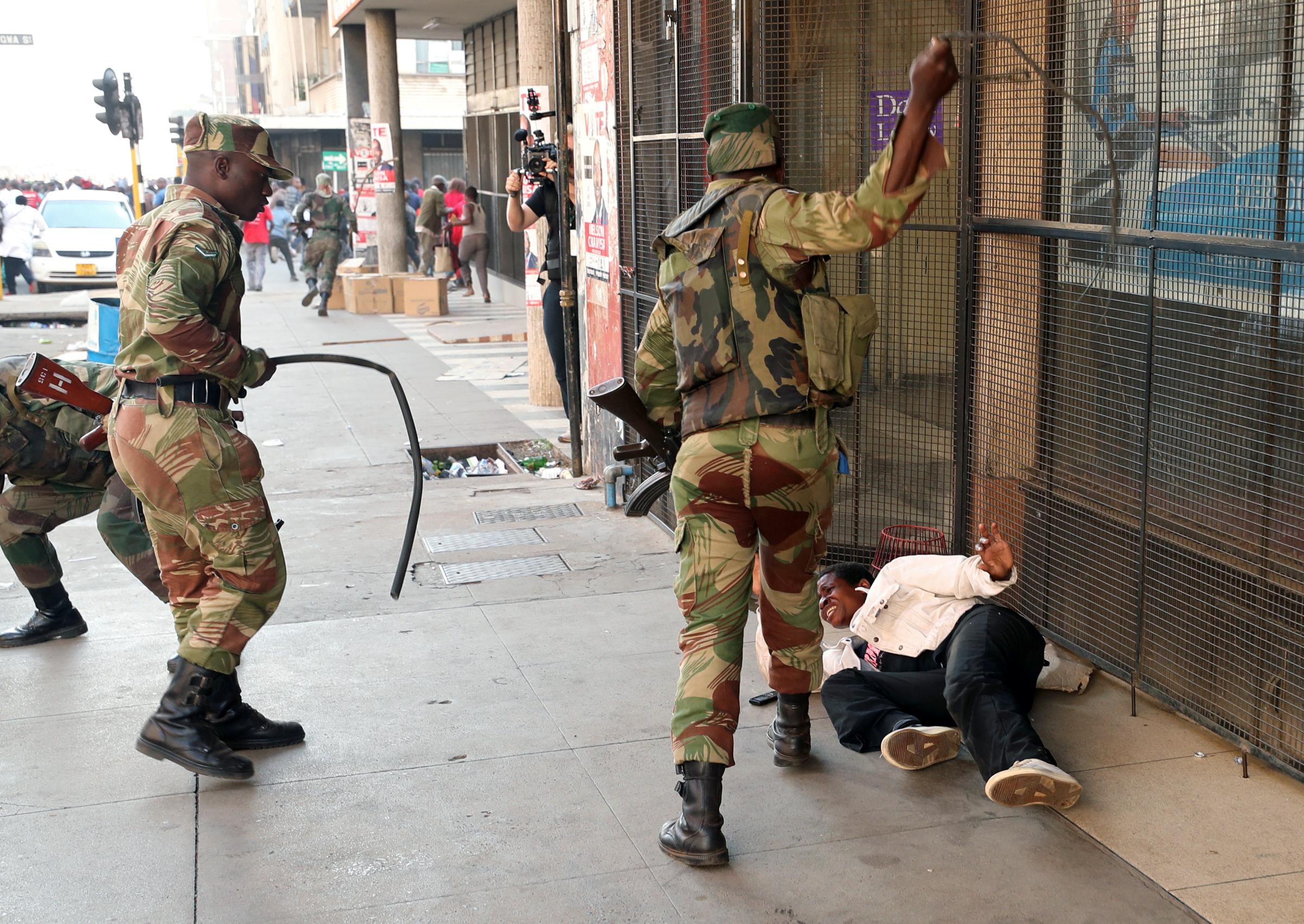 Soldiers beat a supporter of the opposition Movement for Democratic Change party of Nelson Chamisa outside the party's headquarters as they await the results of the general elections in Harare