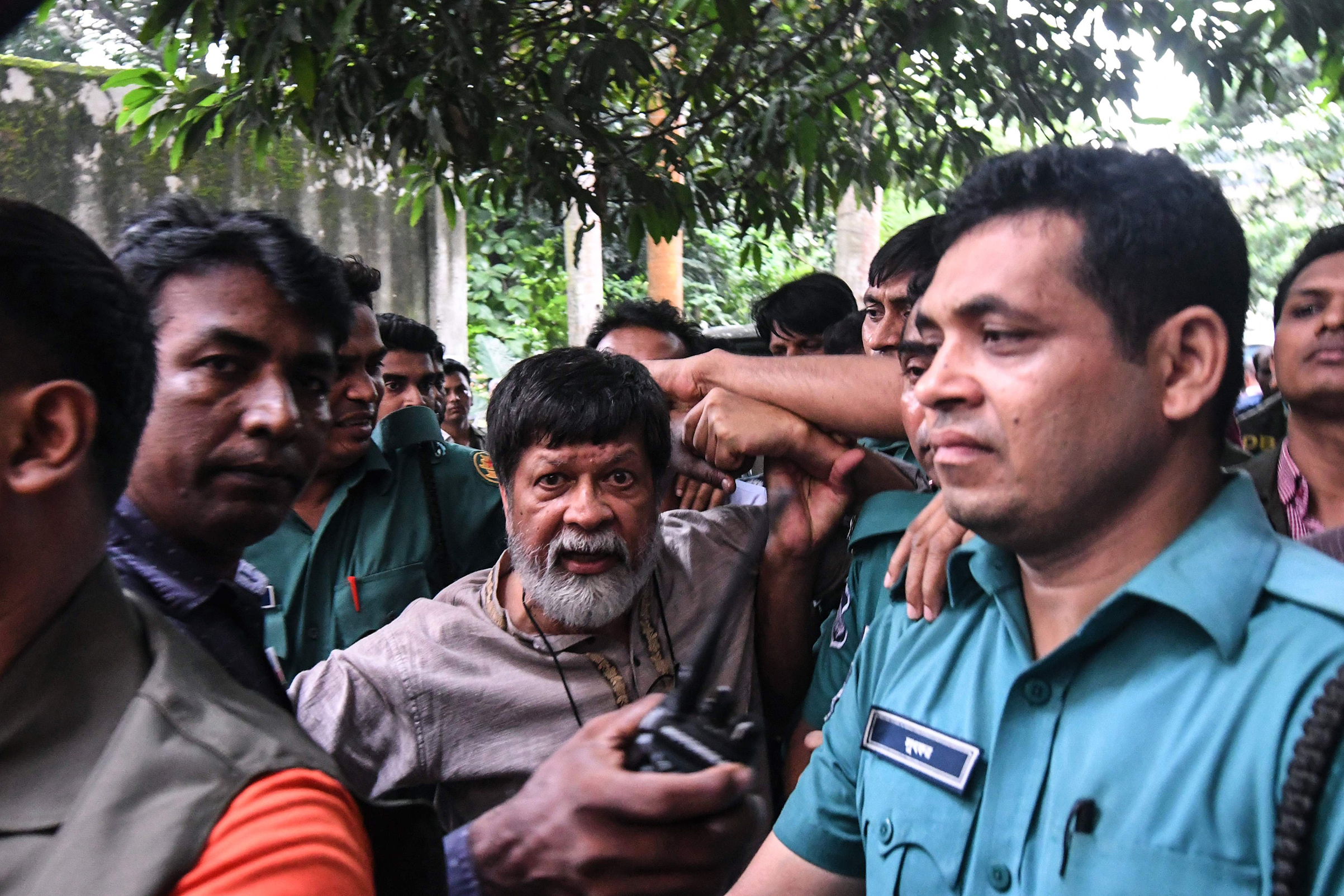 Activists and photographer Shahidul Alam arrives surrounded by policemen for a court appearance in Dhaka on Aug. 6, 2018. (Munir Uz Zaman—AFP/Getty Images)