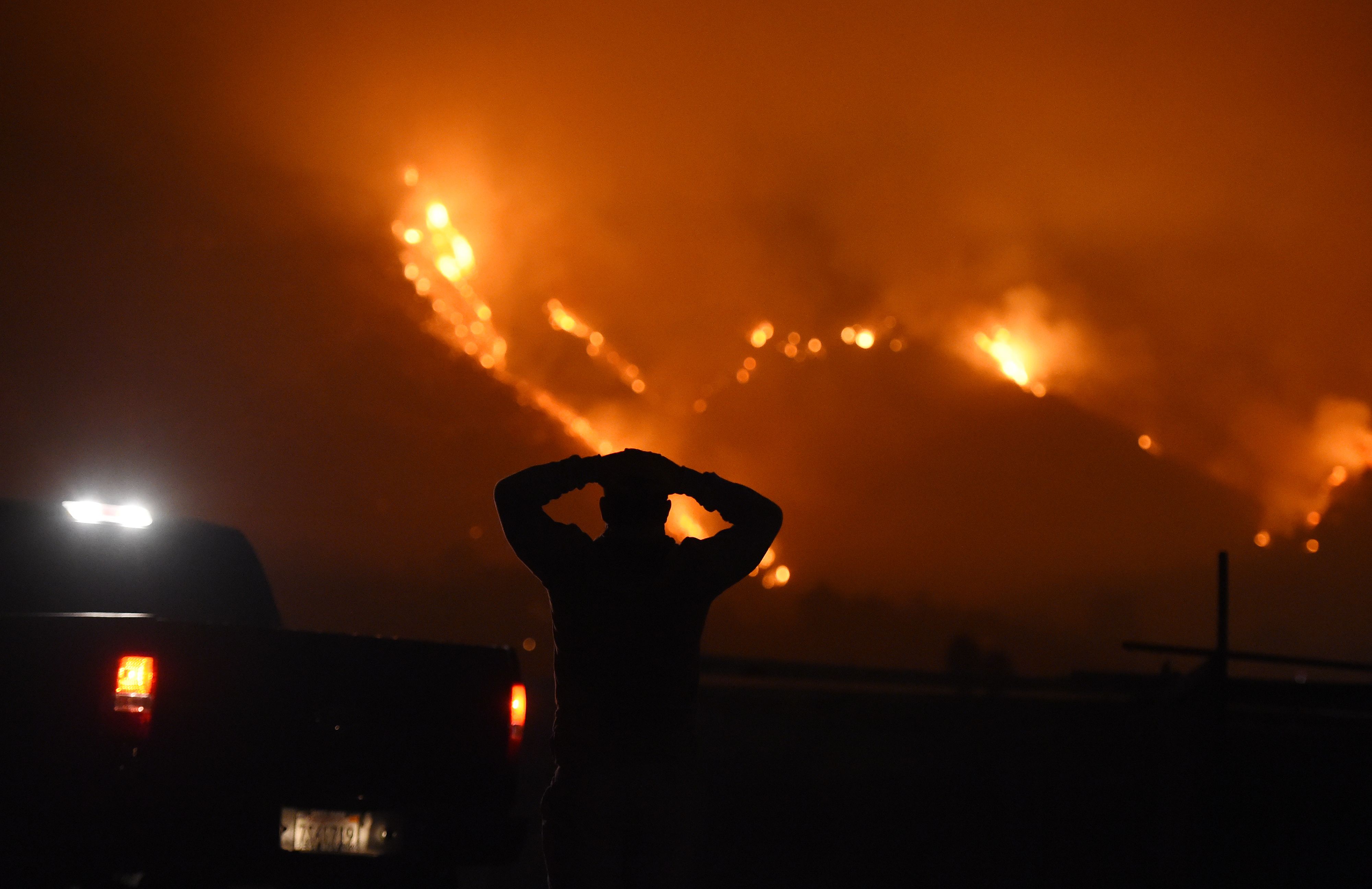 A man watches the Thomas Fire in the hills above Carpinteria, California, December 11, 2017. (ROBYN BECK—AFP/Getty Images)