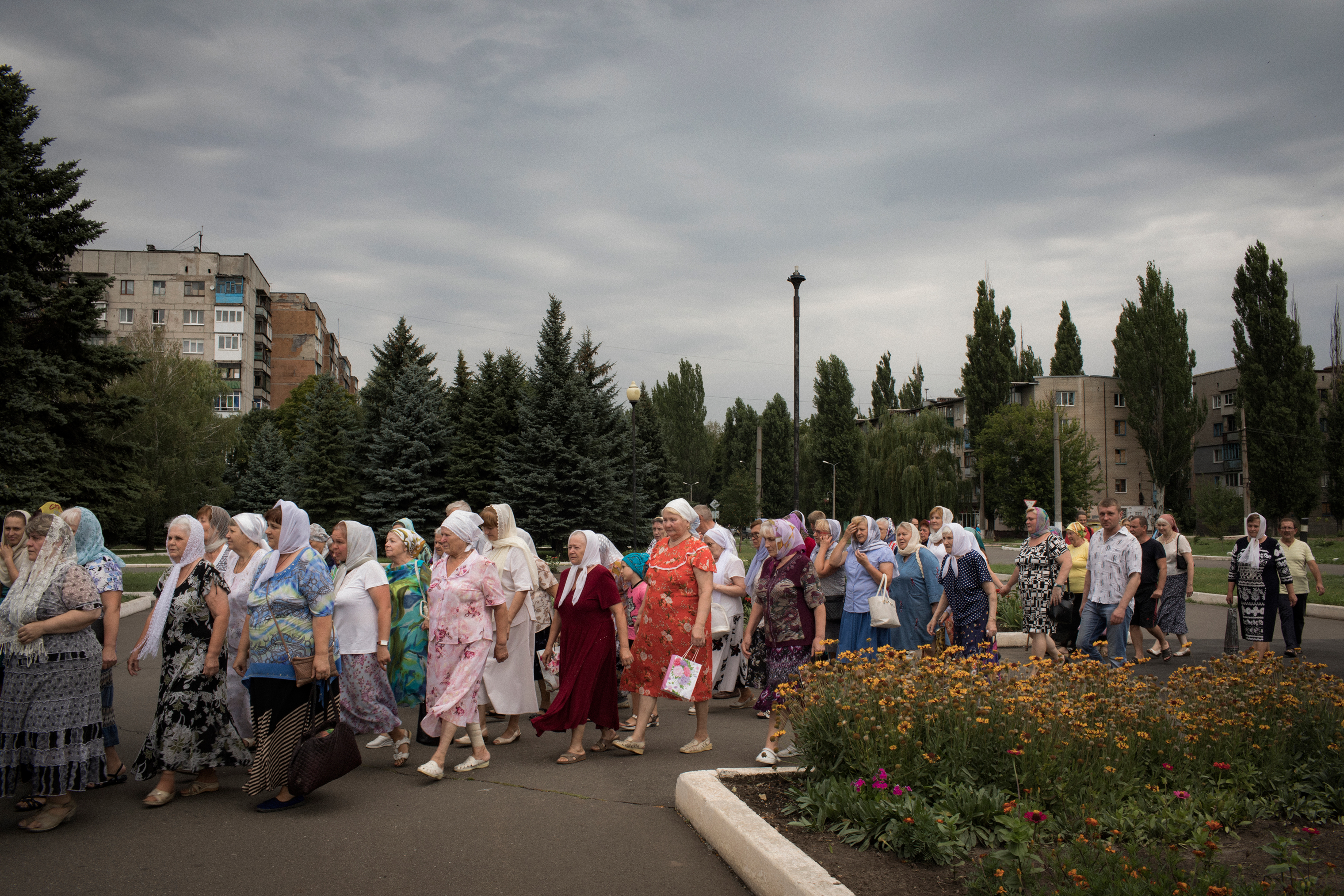 Parishioners participate in a procession in front of the Church of St. Mary Magdalene in Avdeevka. The church stands next to a minefield. (Anastasia Taylor-Lind for eyeWitness)