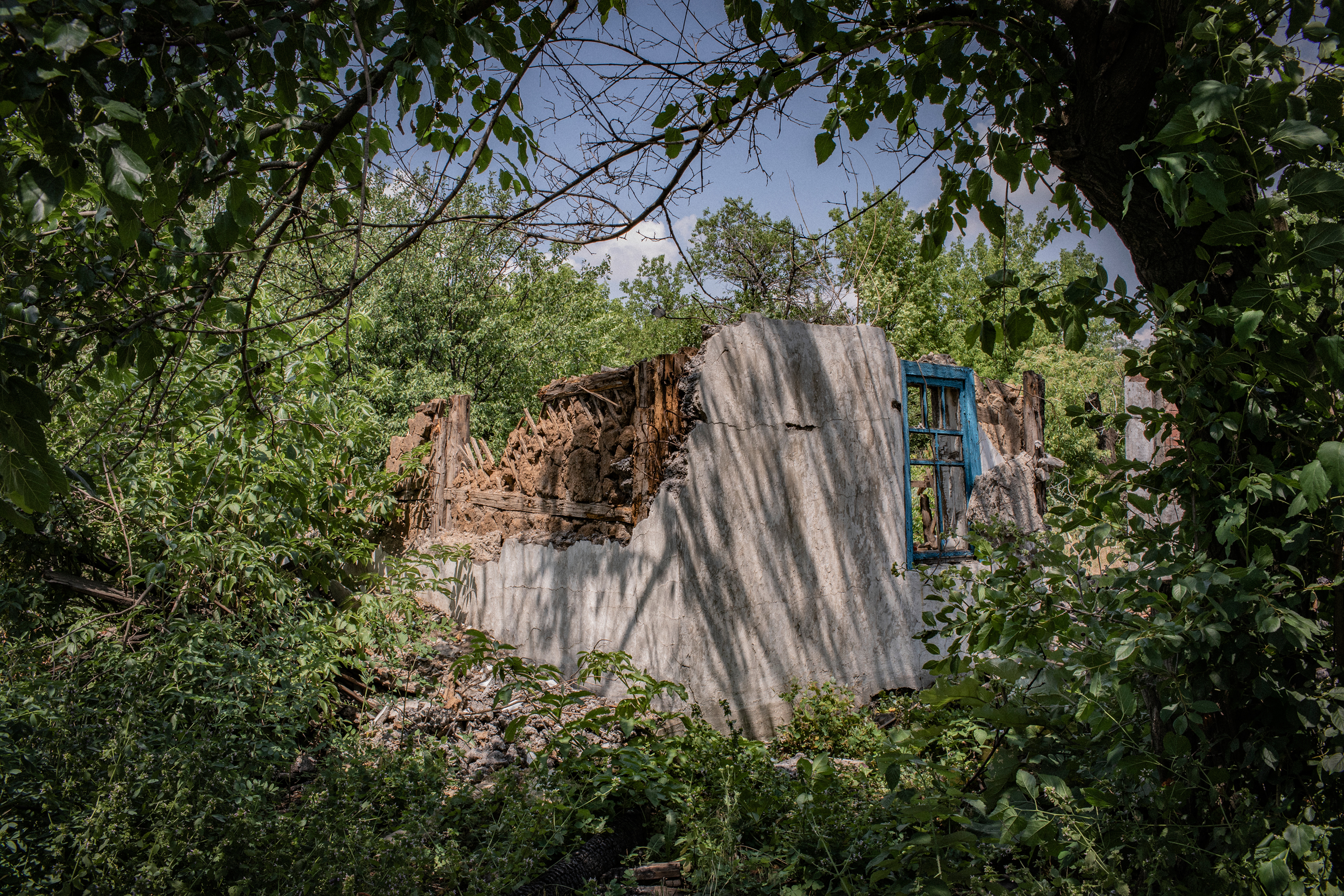 A house that was destroyed by shelling in Yuzhnaya, a frontline area near Toretsk. It's easy for outsiders to see only broken walls, collapsed ceilings and a mess of the mutilated furniture and wallpaper. Yet locals still see their homes, and carry stories about the lives they lived in them. (Anastasia Taylor-Lind for eyeWitness)