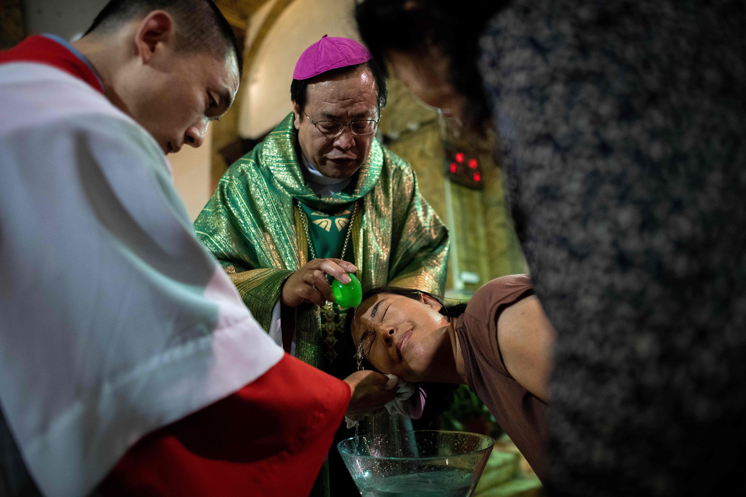 Bishop Joseph Li Shan baptizes a woman at the South Cathedral in Beijing on Sept. 22