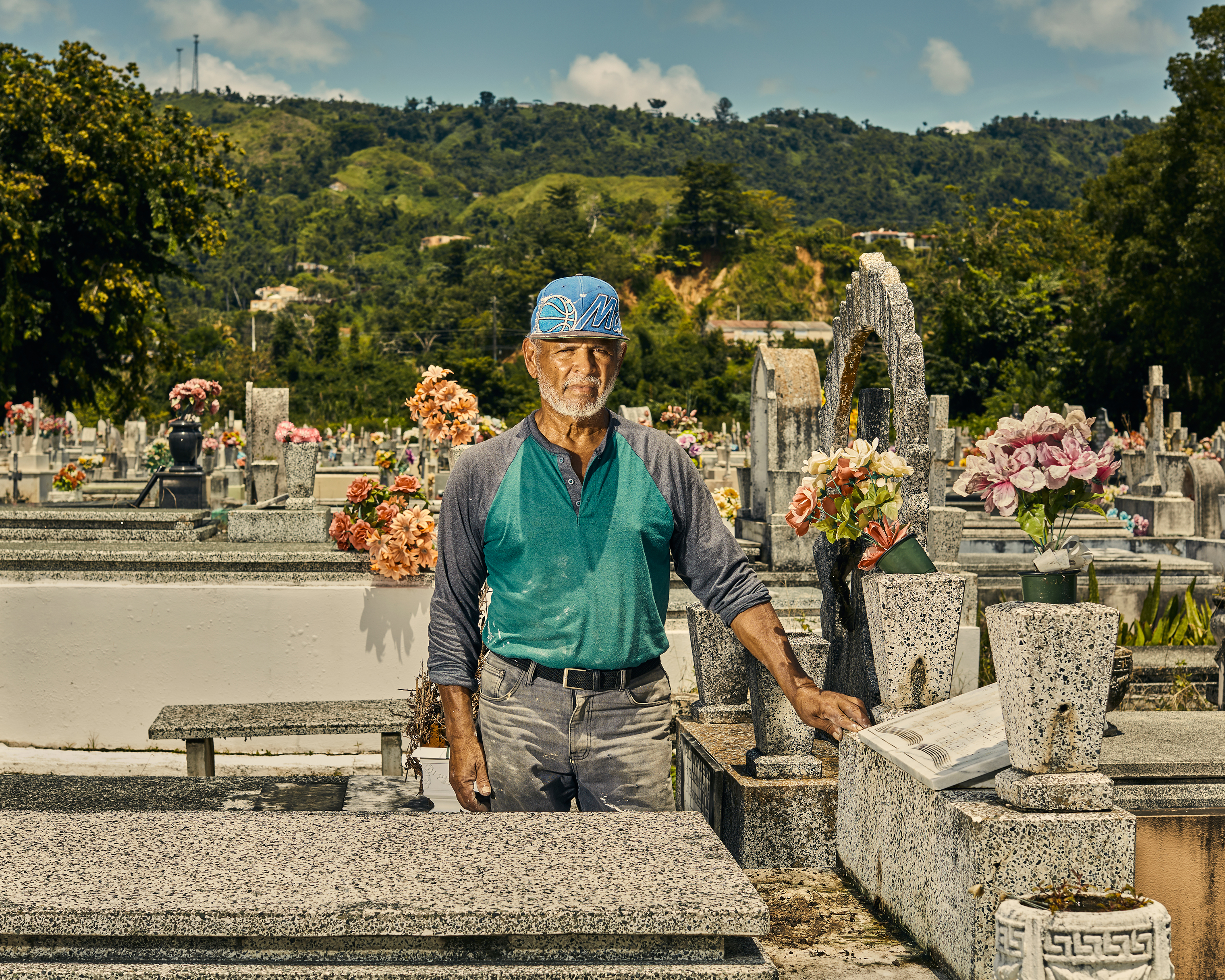Gravekeeper Tulio Collazo Vega poses by the grave of three elderly sisters who where killed by a landslide the day Maria hit Puerto Rico. (Christopher Gregory for TIME)