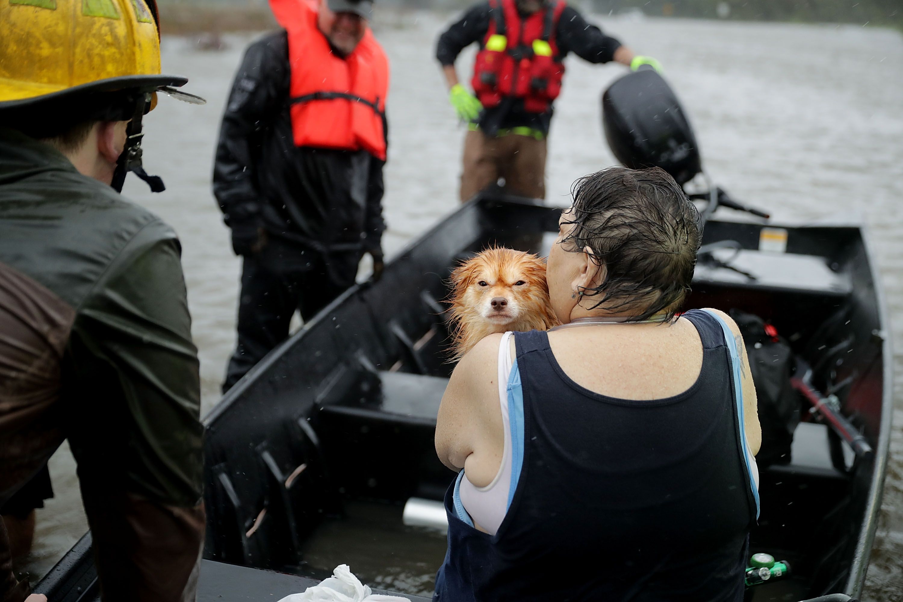 Rescue workers from Township No. 7 Fire Department and volunteers from the Civilian Crisis Response Team use a boat to rescue a woman and her dog from their flooded home during Hurricane Florence in James City, NC on Sept. 14, 2018. (Chip Somodevilla/Getty Images)