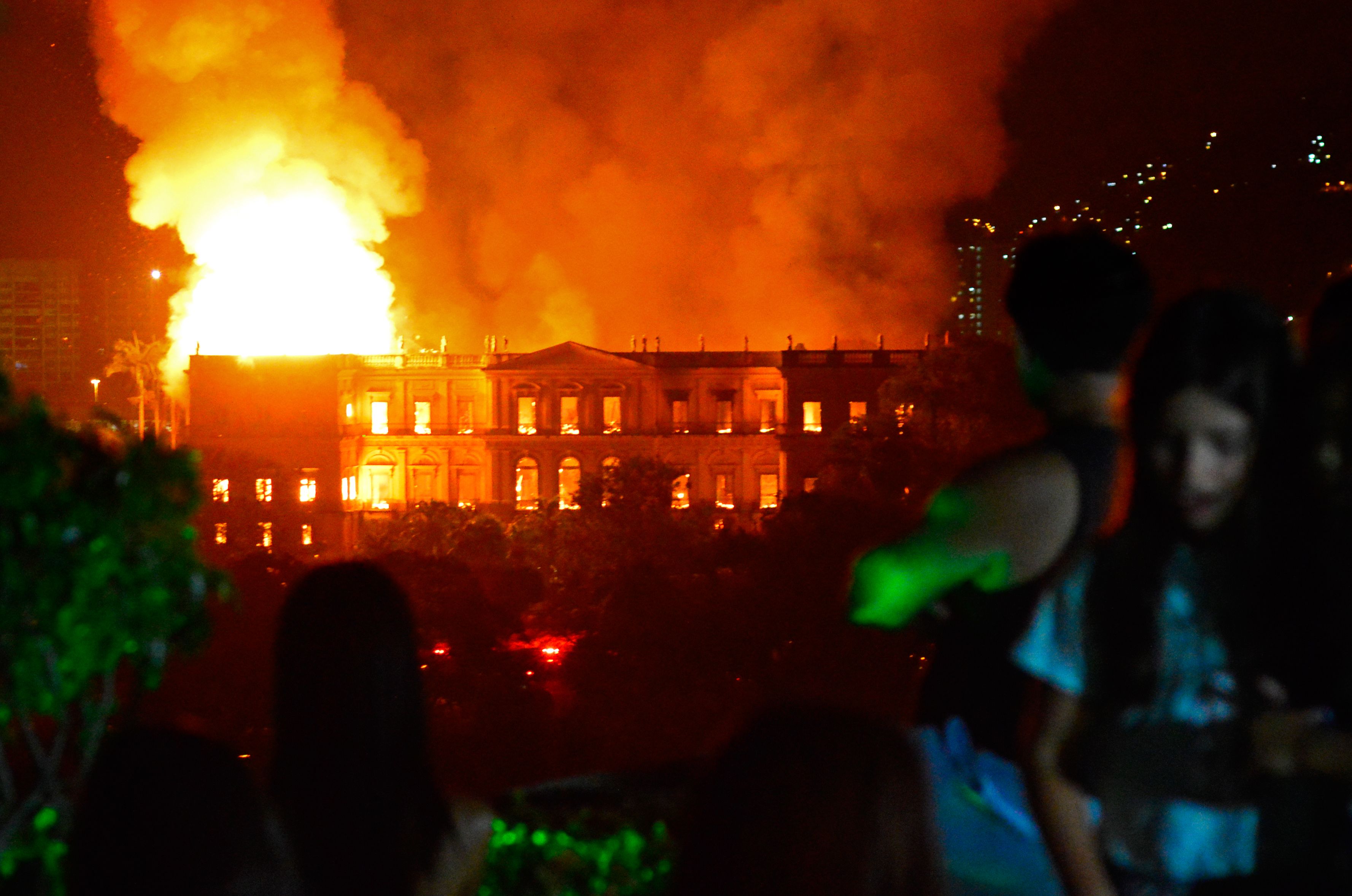 People watch as a massive fire engulfs the National Museum in Rio de Janeiro in Brazil on Sept. 2, 2018. (STR—AFP/Getty Images)