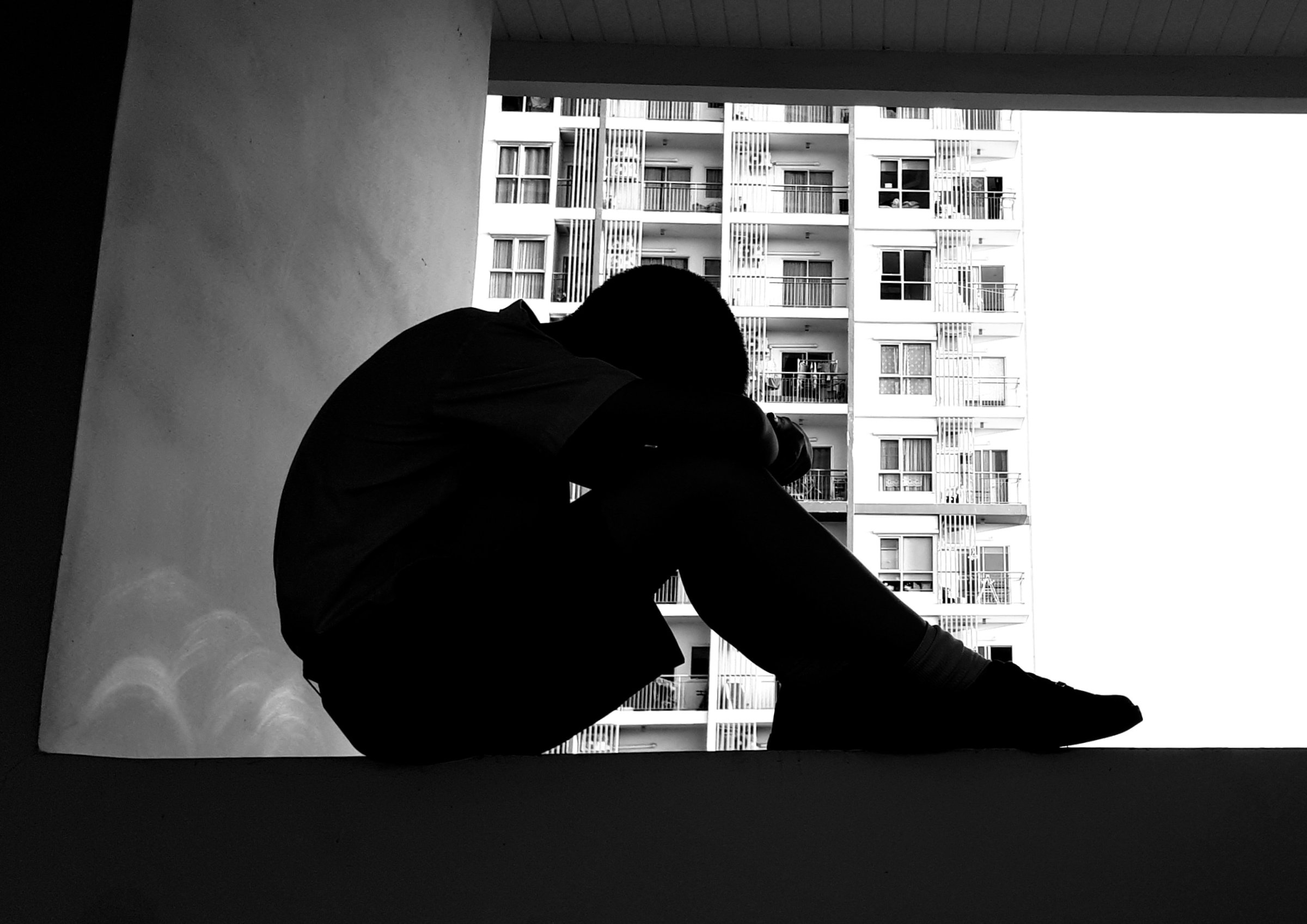 Depressed Boy Sitting On Retaining Wall