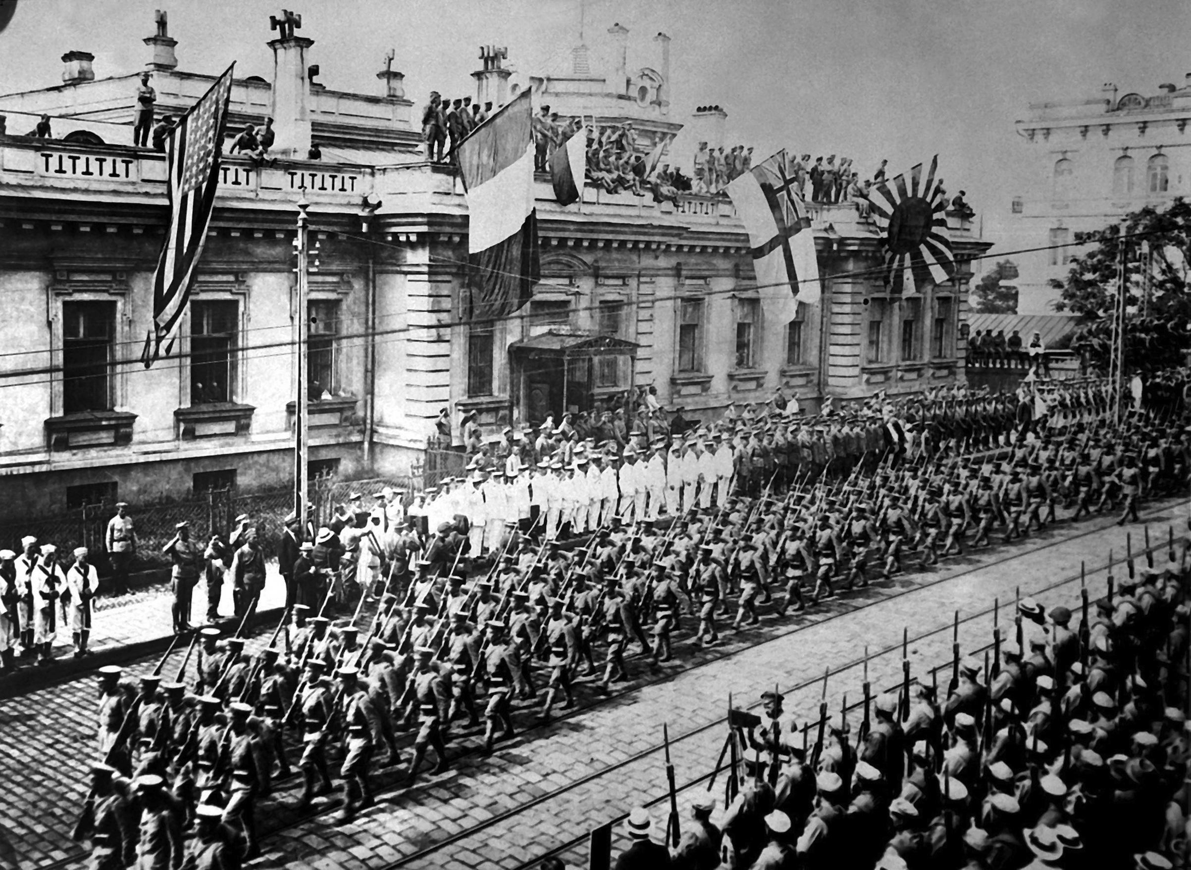Allied soldiers and sailors in Vladivostok, Russia, September 1918. Several foreign powers sent troops to fight on the White (anti-Bolshevik) side in the Russian Civil War. American, French, British and Japanese flags fly from the building in the background. (Heritage Images/Getty Images)