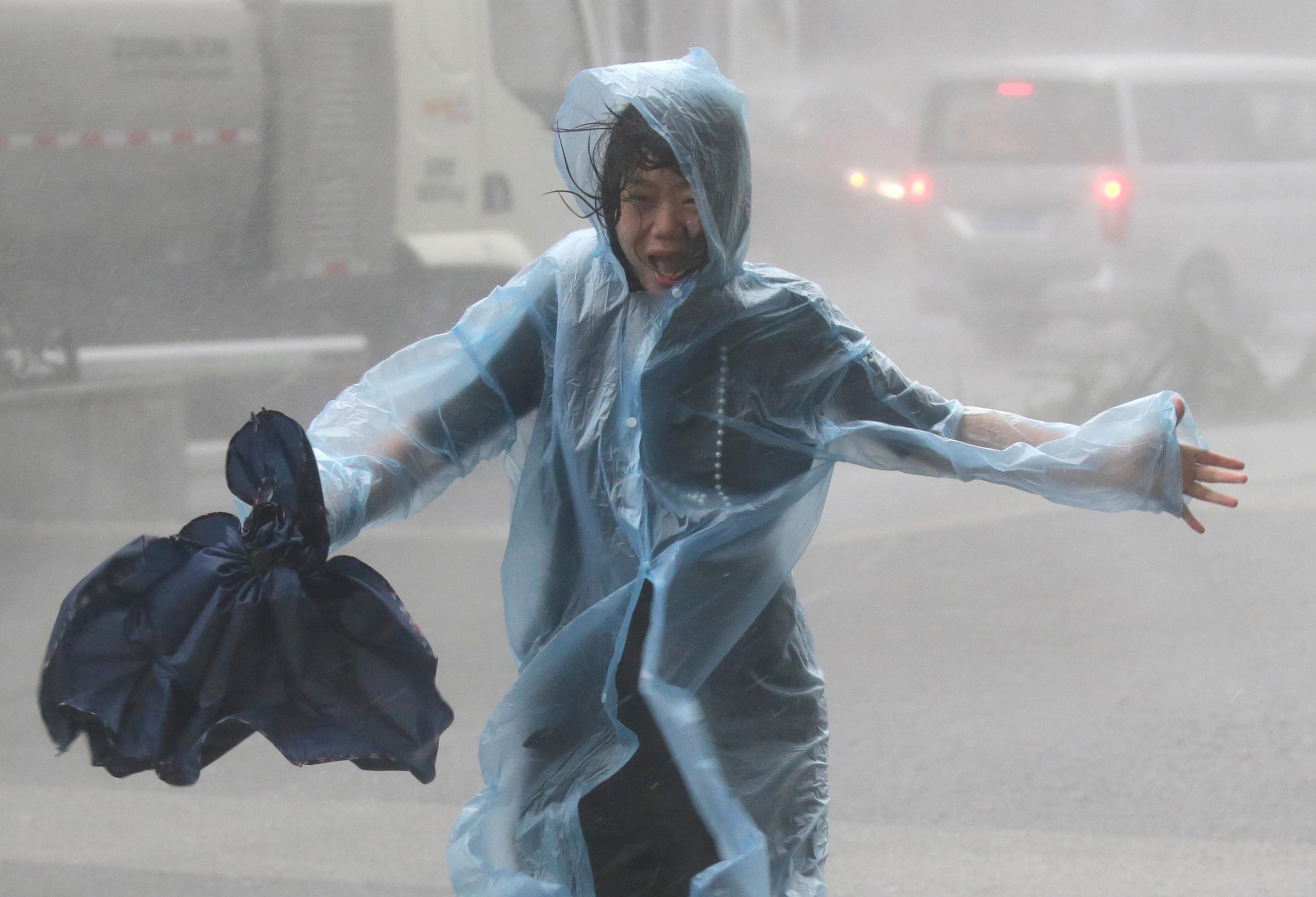 A woman runs in the rainstorm as Typhoon Mangkhut approaches in Shenzhen