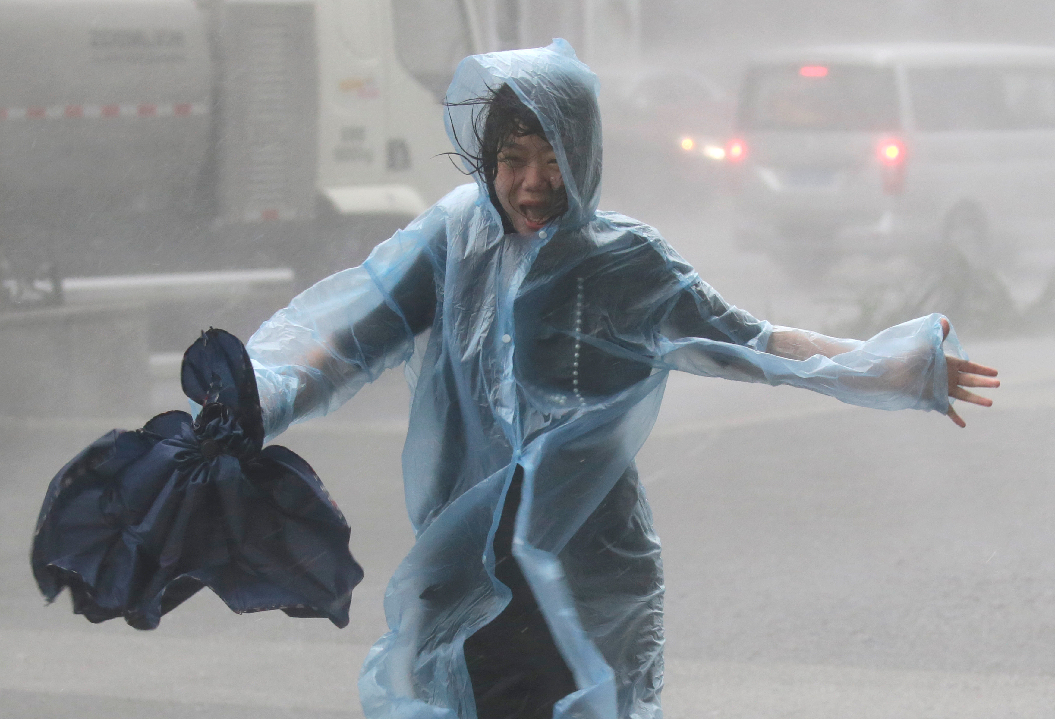 A woman runs in the rainstorm as Typhoon Mangkhut approaches Shenzhen, China on Sept. 16, 2018. (Jason Lee—Reuters)