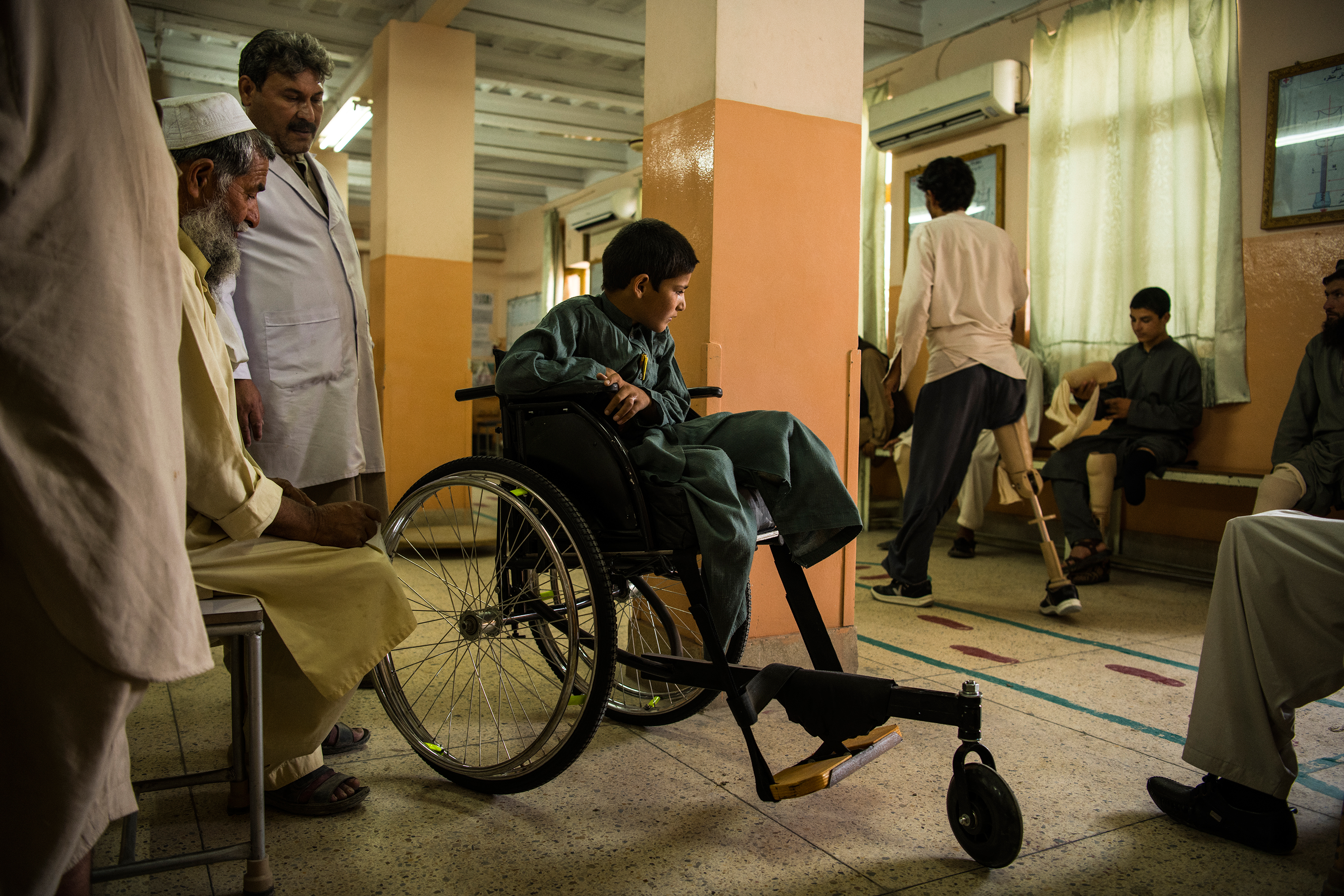 Abdul Rashid watches a patient practice with a prosthetic leg at the orthopedic center on June 27. (Andrew Quilty for TIME)
