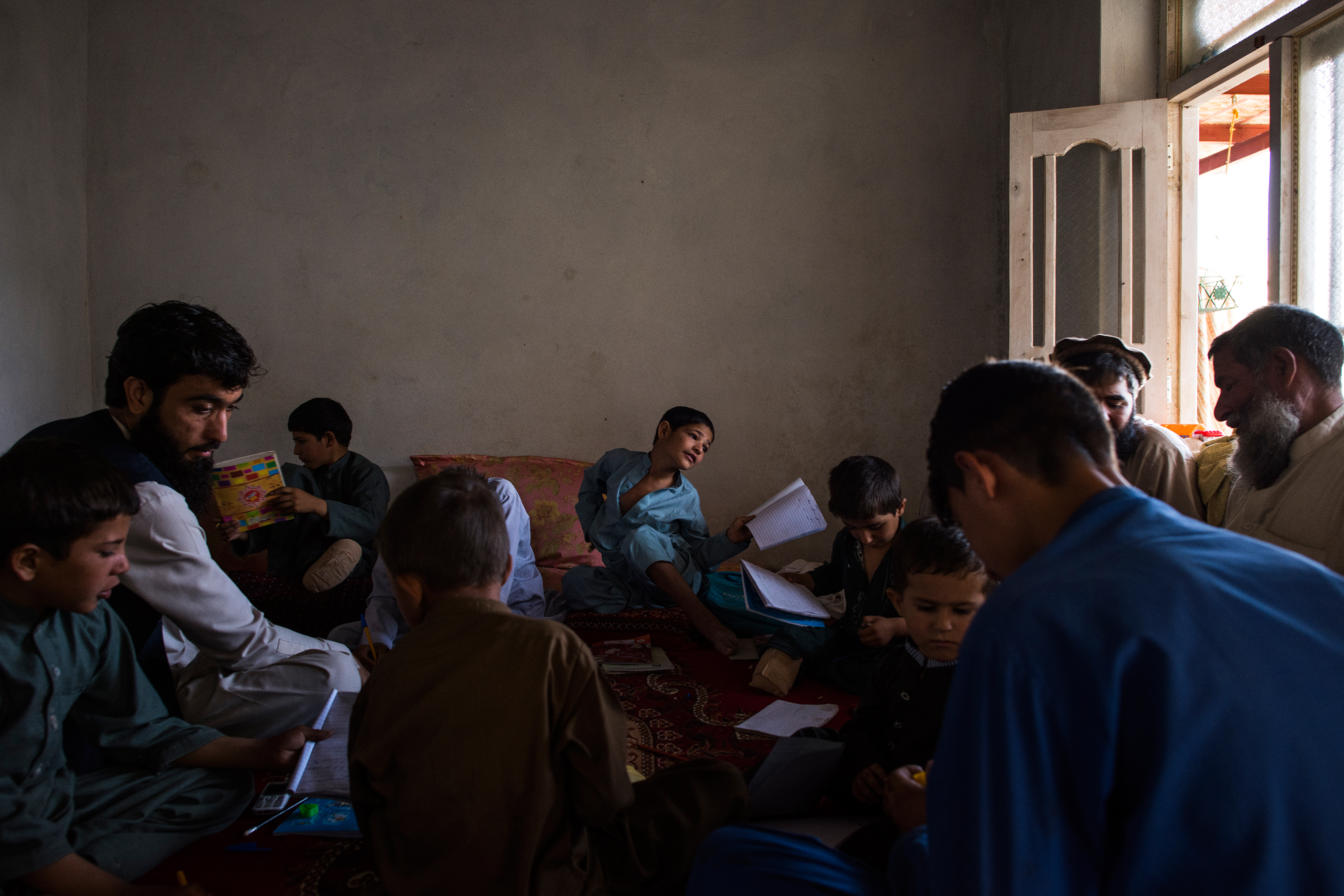 During the children's recovery, they continued to study with a teacher provided by a small charity, Enabled Children. This lesson, in June, was conducted at a neighbor's home as their own was undergoing construction work. (Andrew Quilty for TIME)