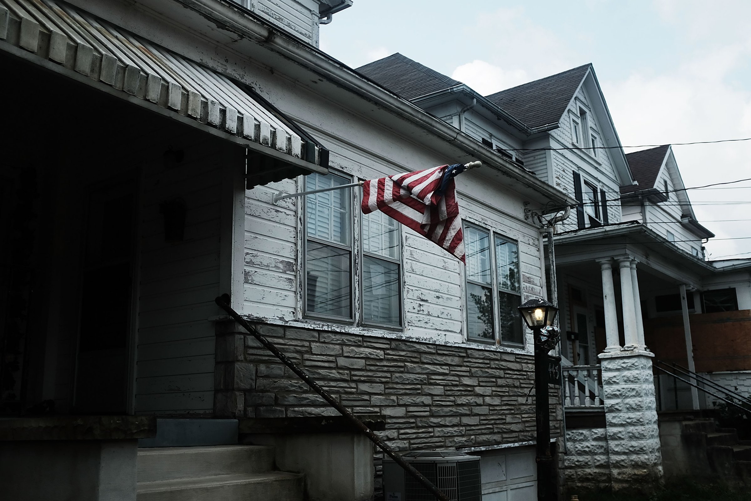 An American flag hangs outside of a home in Clarksburg, WV on Aug. 22, 2018, a state still struggling with endemic poverty and opioid abuse.