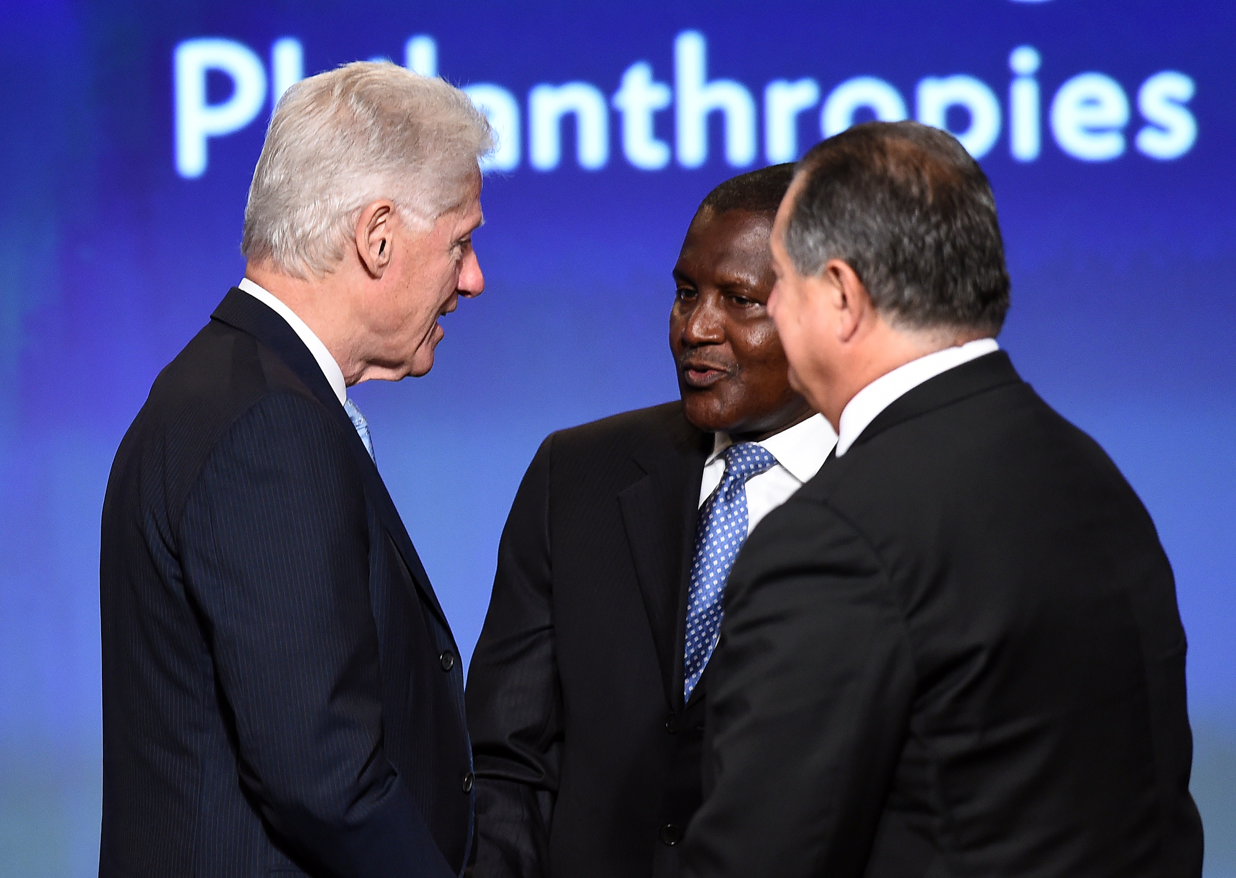 Former U.S. President Bill Clinton (L) speaks with Aliko Dangote (C), President and CEO, Dangote Group, and Andrew N. Liveris, President, Chairman & CEO, at the end of a panel discussion during US-Africa Business Forum on the sideline of the US-Africa Leaders Summit in Washington, DC, on August 5, 2014. (Jewel Samad—AFP/Getty Images)