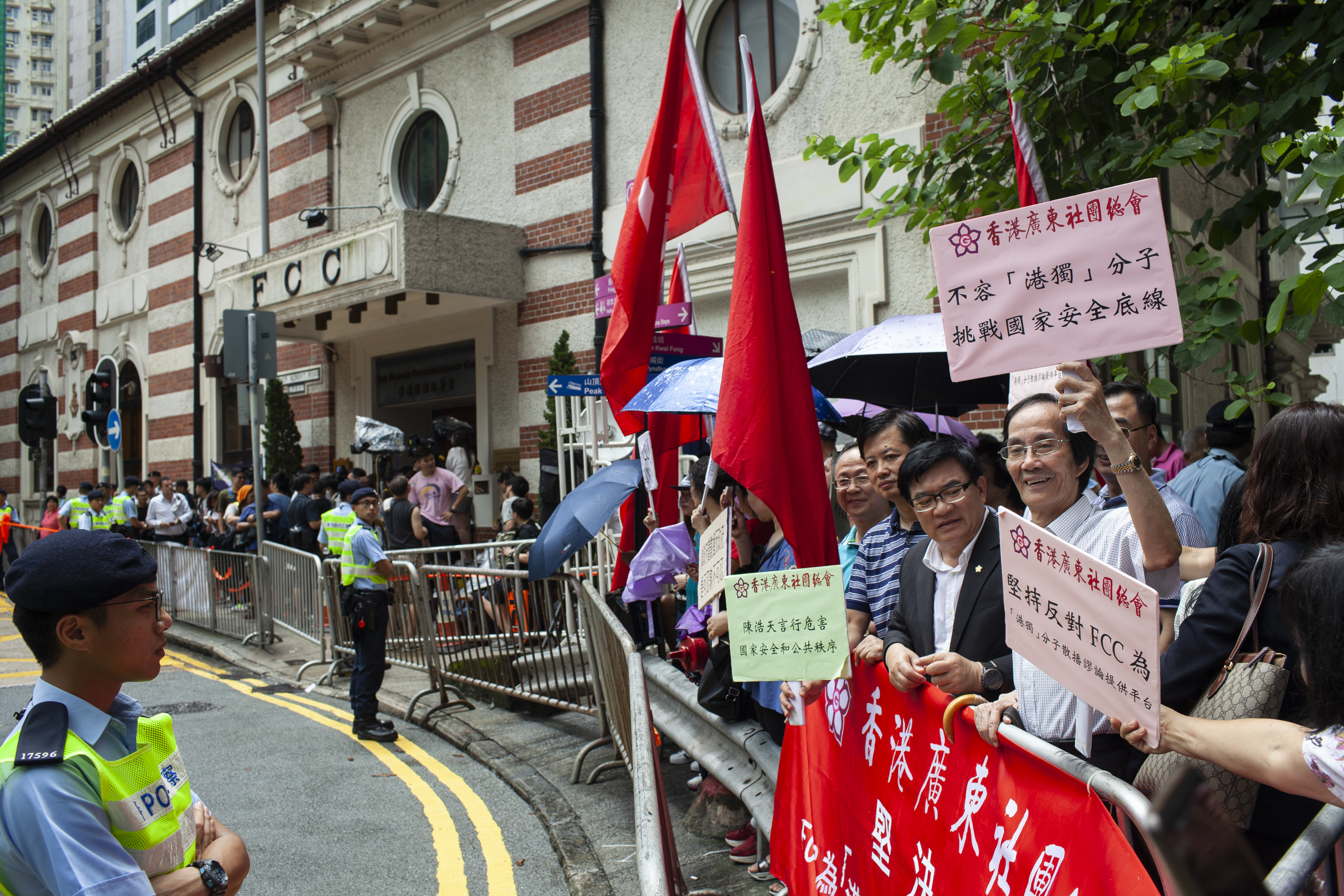 Pro-China demonstrators hold signs outside the Foreign Correspondents Club in Hong Kong on Aug. 13, 2018. (Viola Gaskell—SOPA Images/LightRocket/Getty Images)