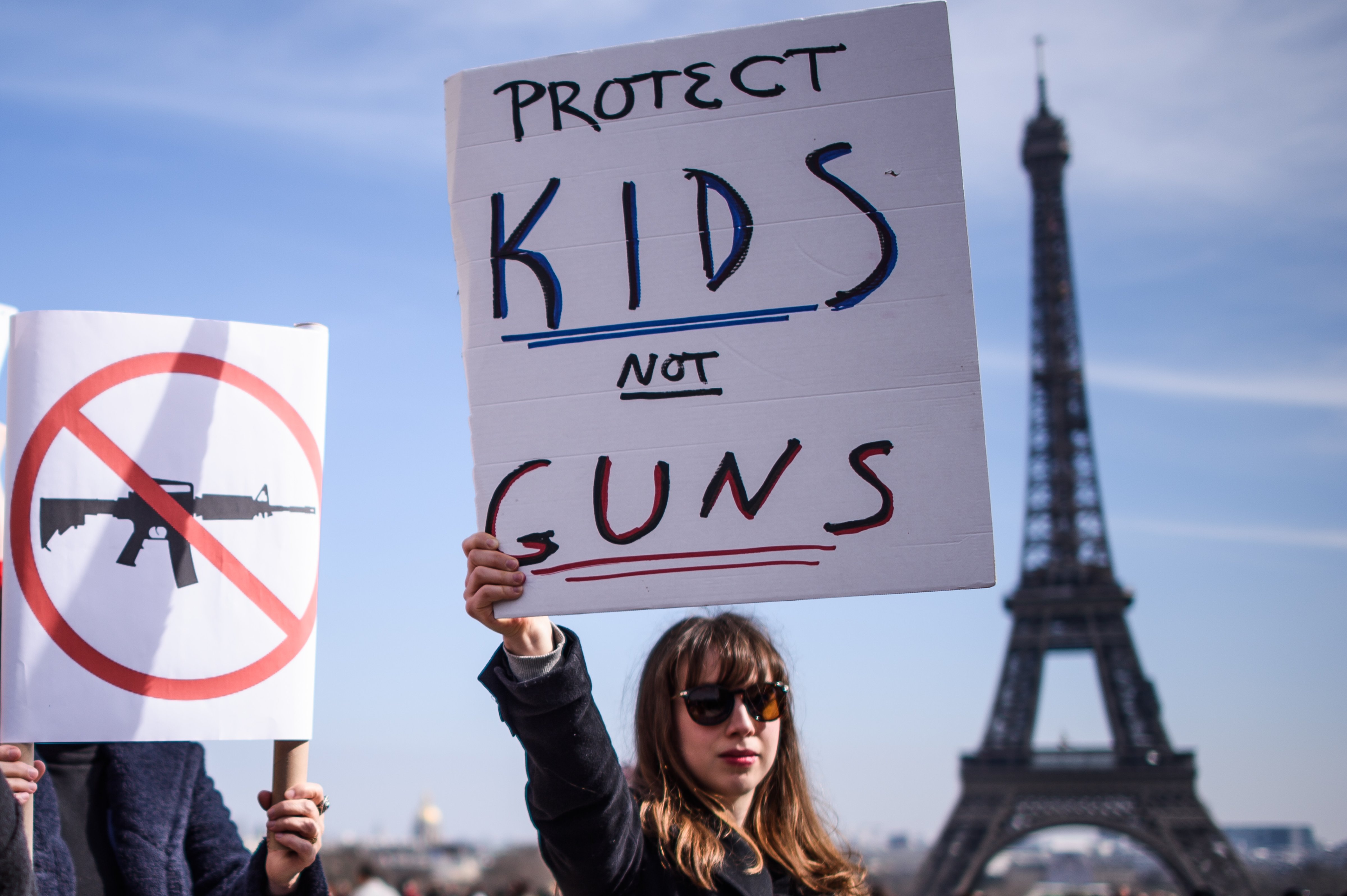 A woman holds a poster as protesters gather near the Eiffel Tower in support of the 'March For Our Lives' movement in Paris, France on March 24, 2018. (Christophe Petit Tesson—EPA-EFE)