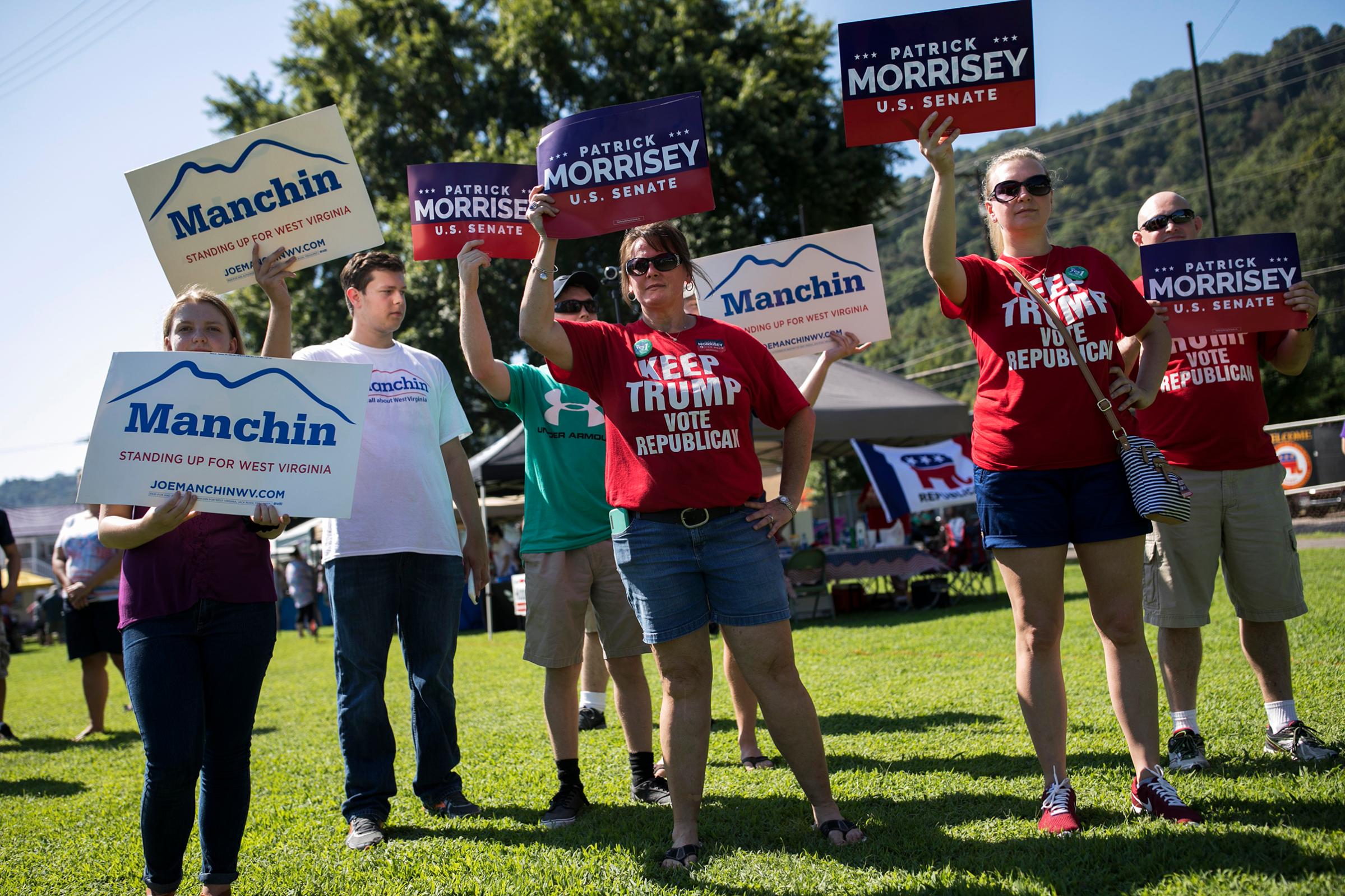 Demonstrators campaign on Sept. 3 in Marmet, W.Va., in a Senate race that has centered on health care