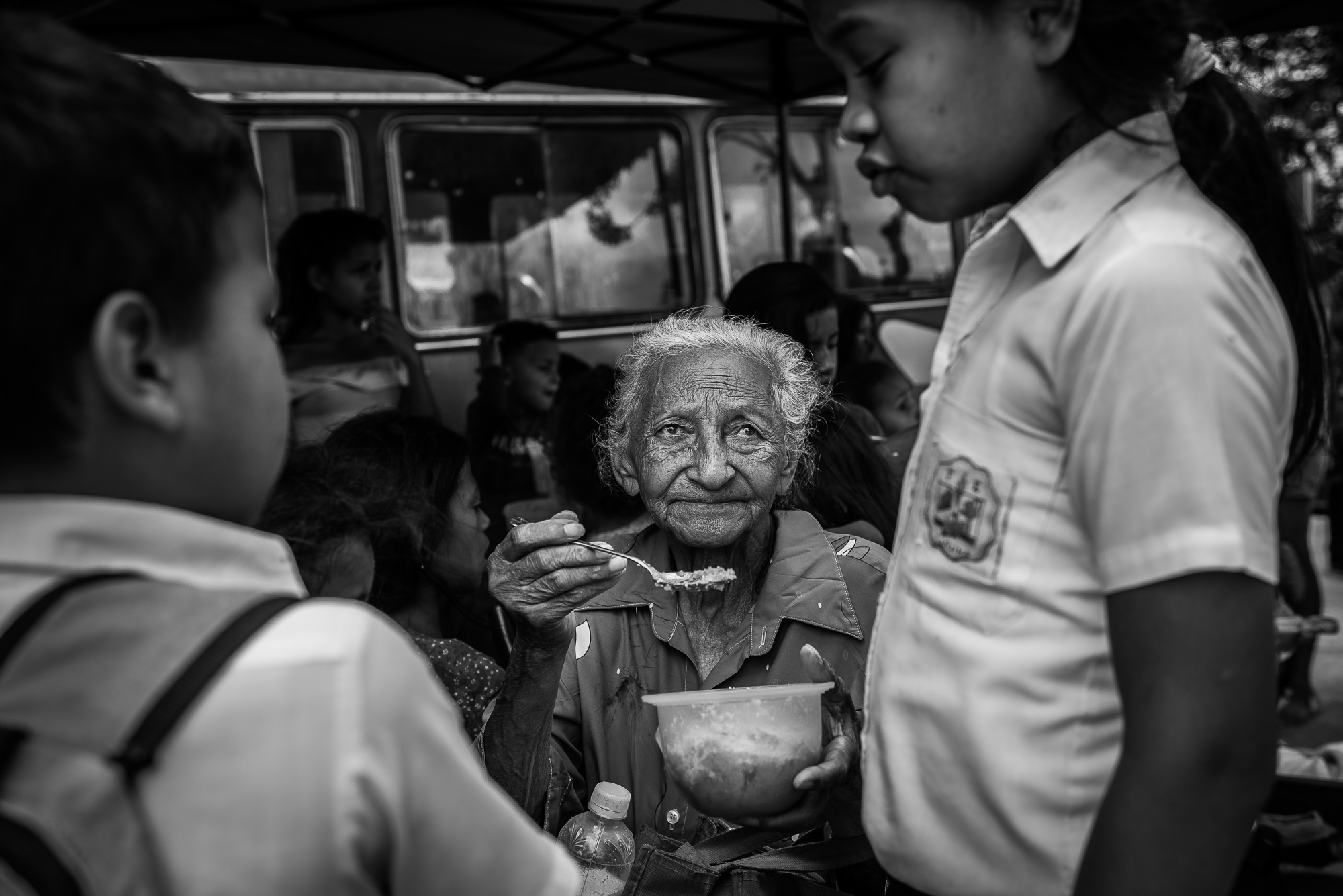 A grandmother feeds her grandchild at a charity kitchen run by volunteers and the NGO Caracas Mi Convive in East Caracas. (Ignacio Marin)