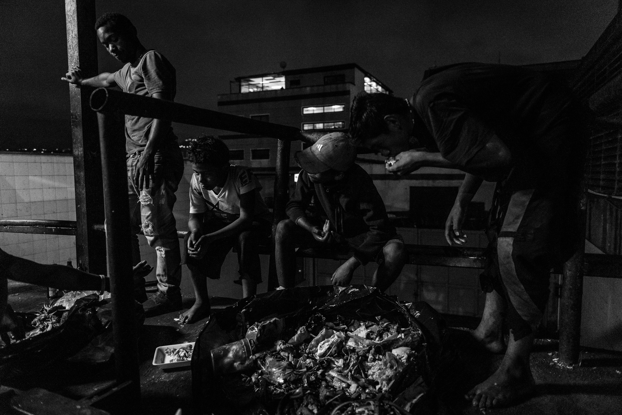 Children scavenge for food in the back alley of a large shopping center. (Ignacio Marin)