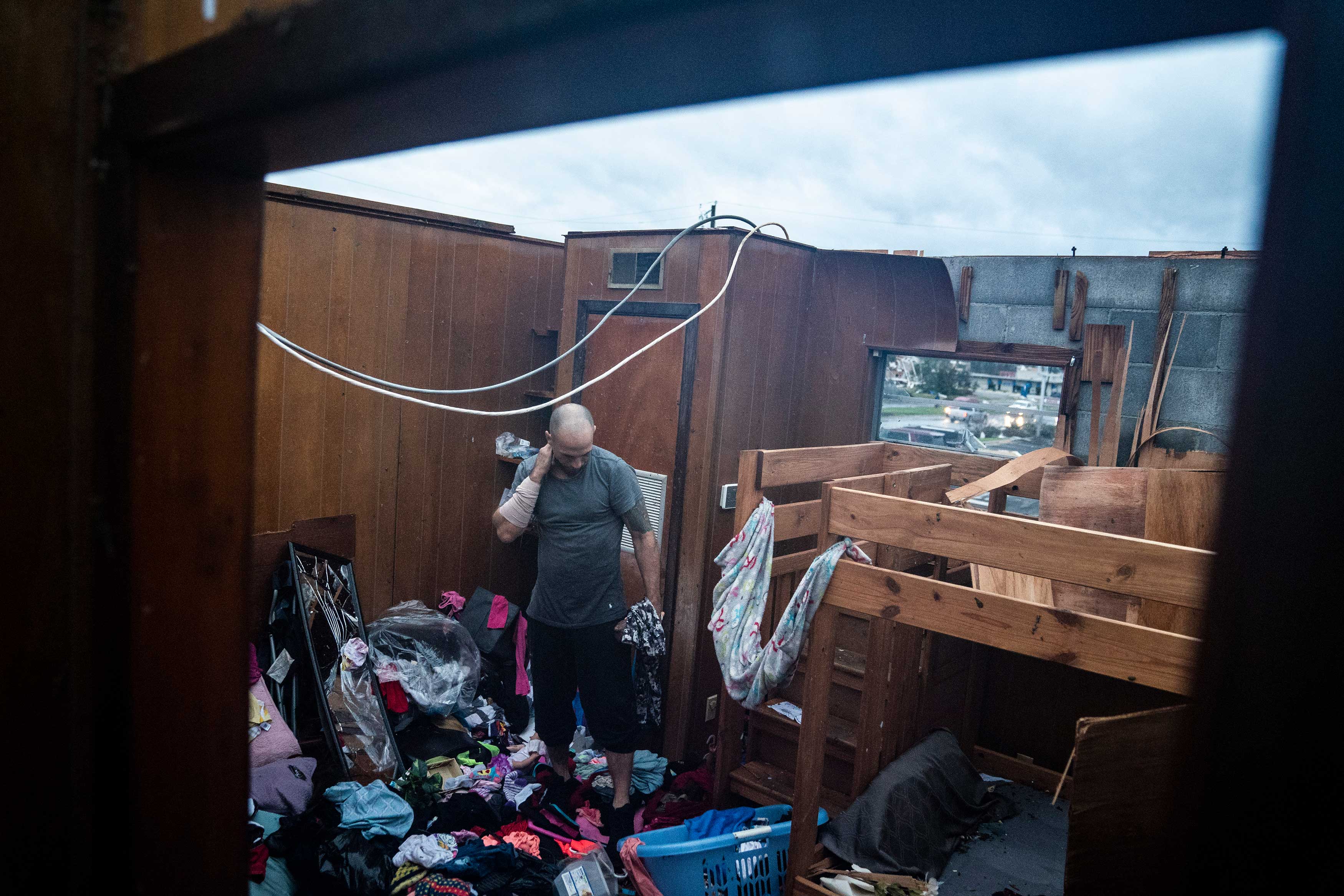 Jason Phipps looks through his families roofless apartment after category 4 Hurricane Michael made land fall along the Florida panhandle, on Oct. 10, 2018 in Panama City, Fla. (Jabin Botsford—The Washington Post/Getty Images)