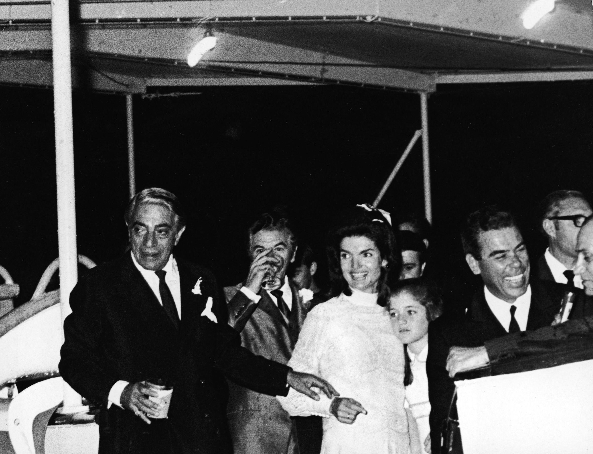 Jacqueline Kennedy Onassis, embracing her daughter, Caroline Kennedy, and her new husband, Greek shipping magnate Aristotle Onassis at their wedding reception aboard the yacht, <i>Christina</i>, shortly after they tied the knot on the Island of Skorpios, Greece, on Oct. 21, 1968. (Express Newspapers—Getty Images)