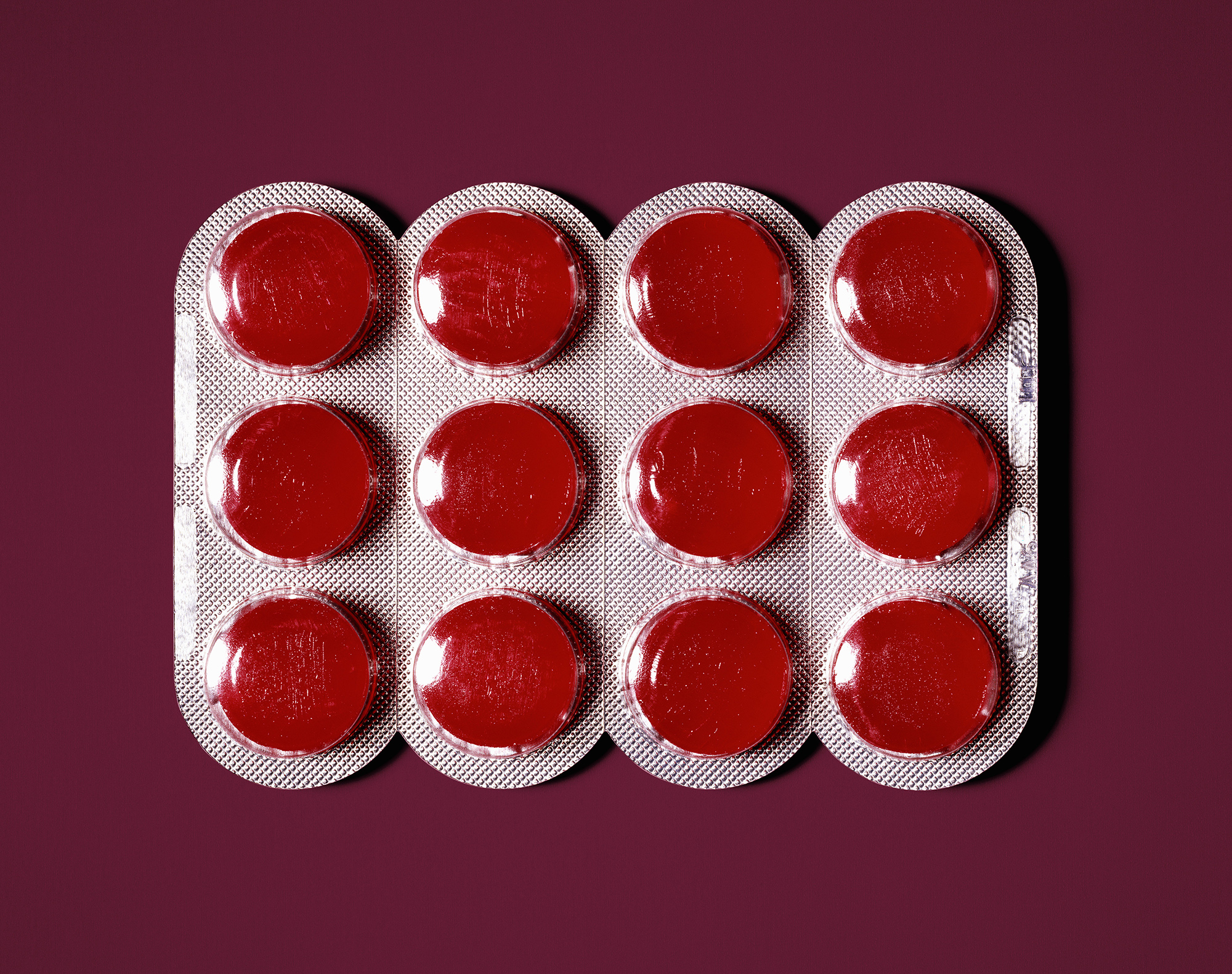 Red lozenges in blister pack, close-up