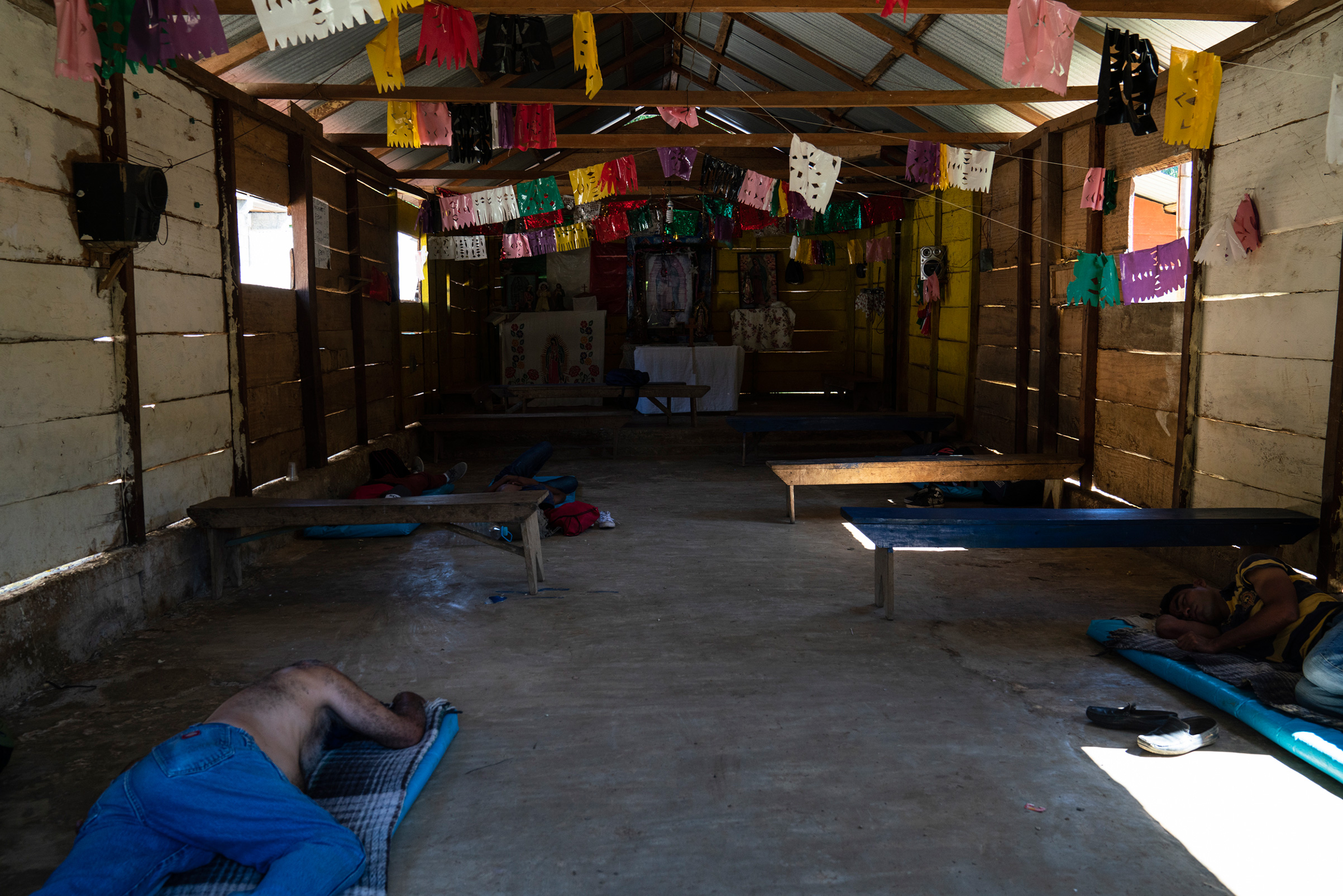 Honduran migrants Juan Ramón Andino, 60, left and José, 40, right, sleep in a church that also serves as a migrant shelter in General Emiliano Zapata del Valle near Palenque, Chiapas, on Oct. 24. The shelter is located along highway 307, known as "The Great Pacific Corridor of the Migrant," and is a common route for Honduran migrants. (Veronica G. Cardenas for TIME)