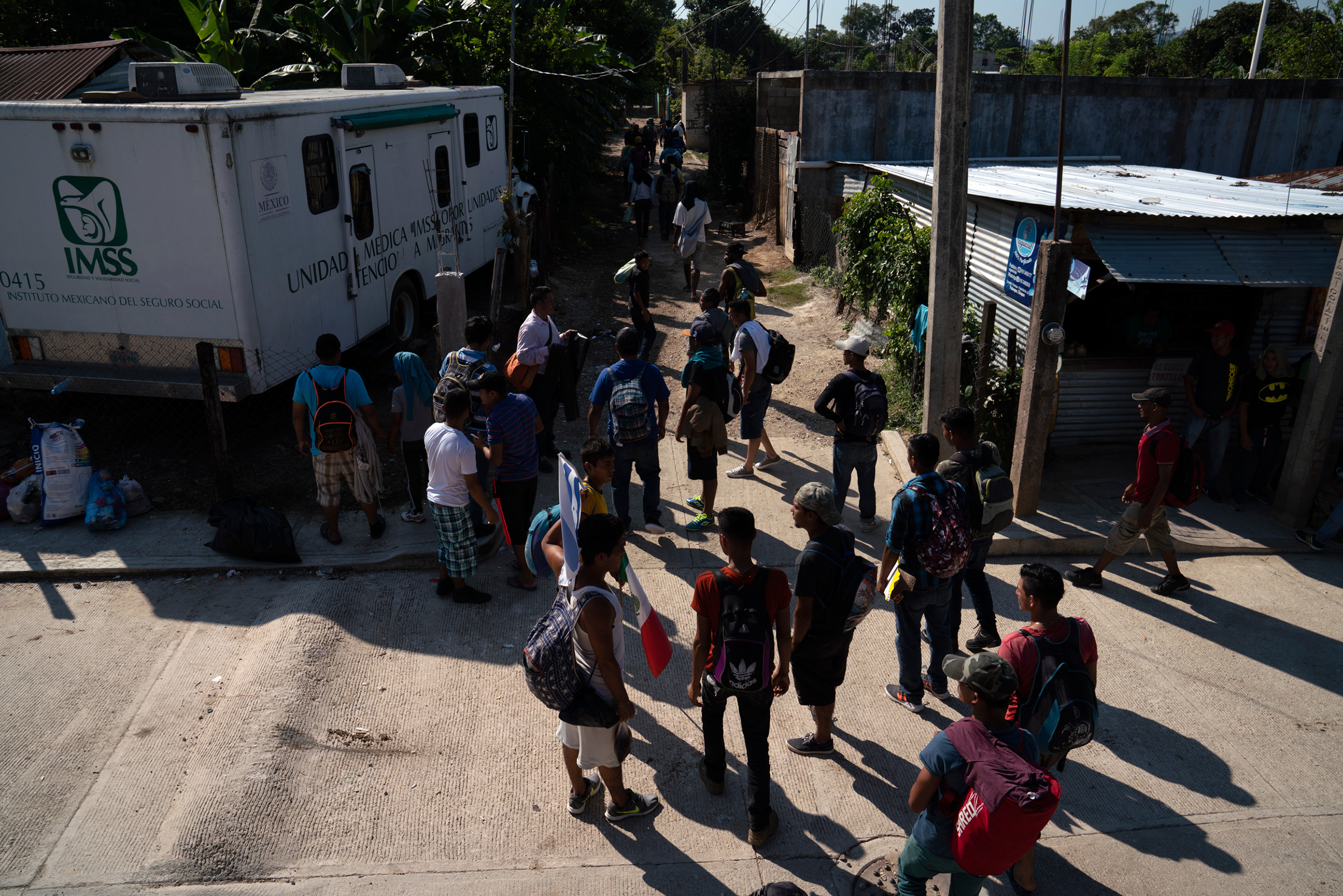 More than 50 migrants, 49 Honduran and one Guatemalan, walk to the nearest train station near Palenque, Chiapas, on Oct. 26. The group will be heading north by traveling on freight trains through México. They decided to travel as a group to be better protected from thieves, police, and Mexican immigration officers. (Veronica G. Cardenas for TIME)