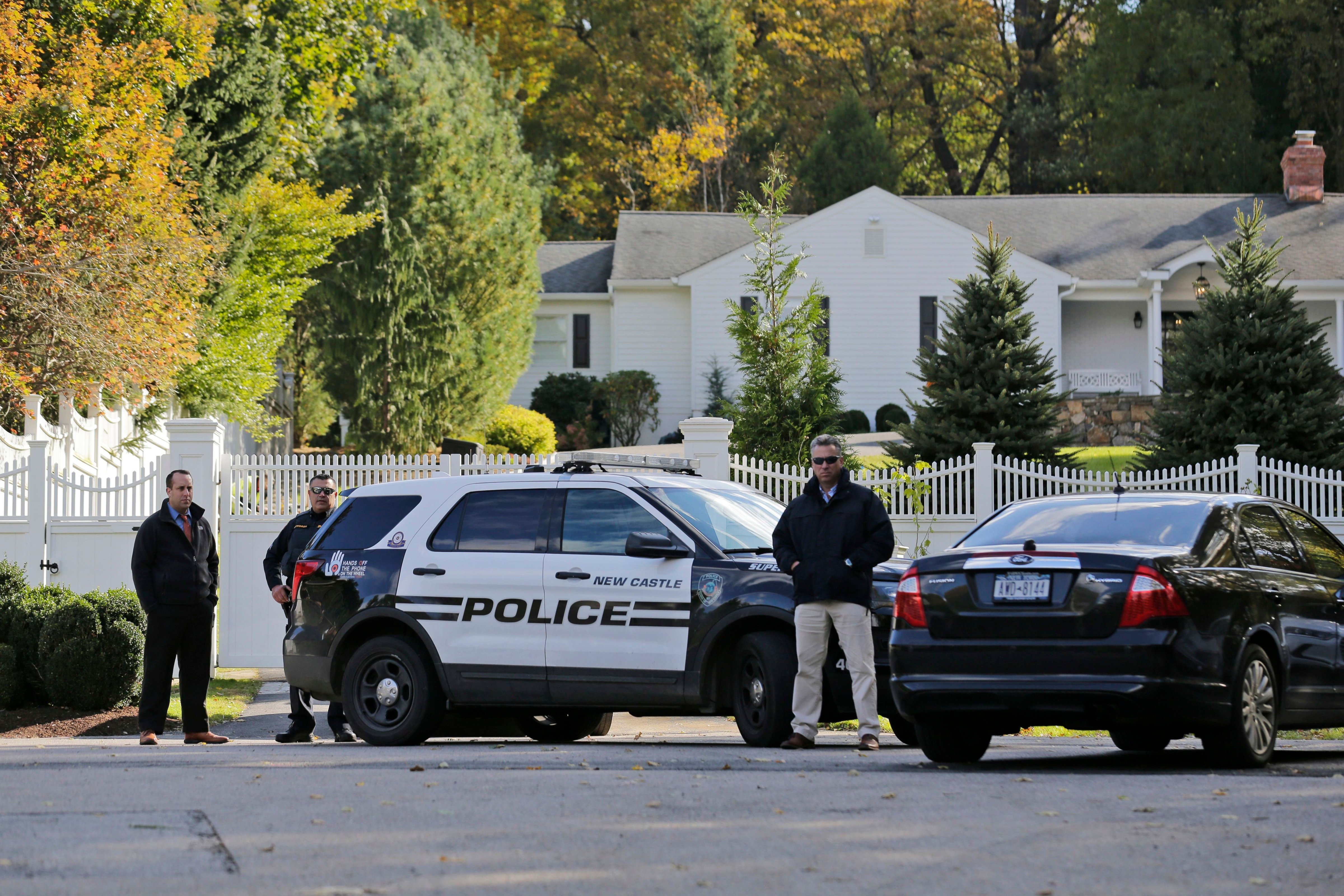 Police officers stand in front of property owned by Hillary and Bill Clinton in Chappaqua, N.Y., on Oct. 24, 2018. (Seth Wenig—AP/REX/Shutterstock)