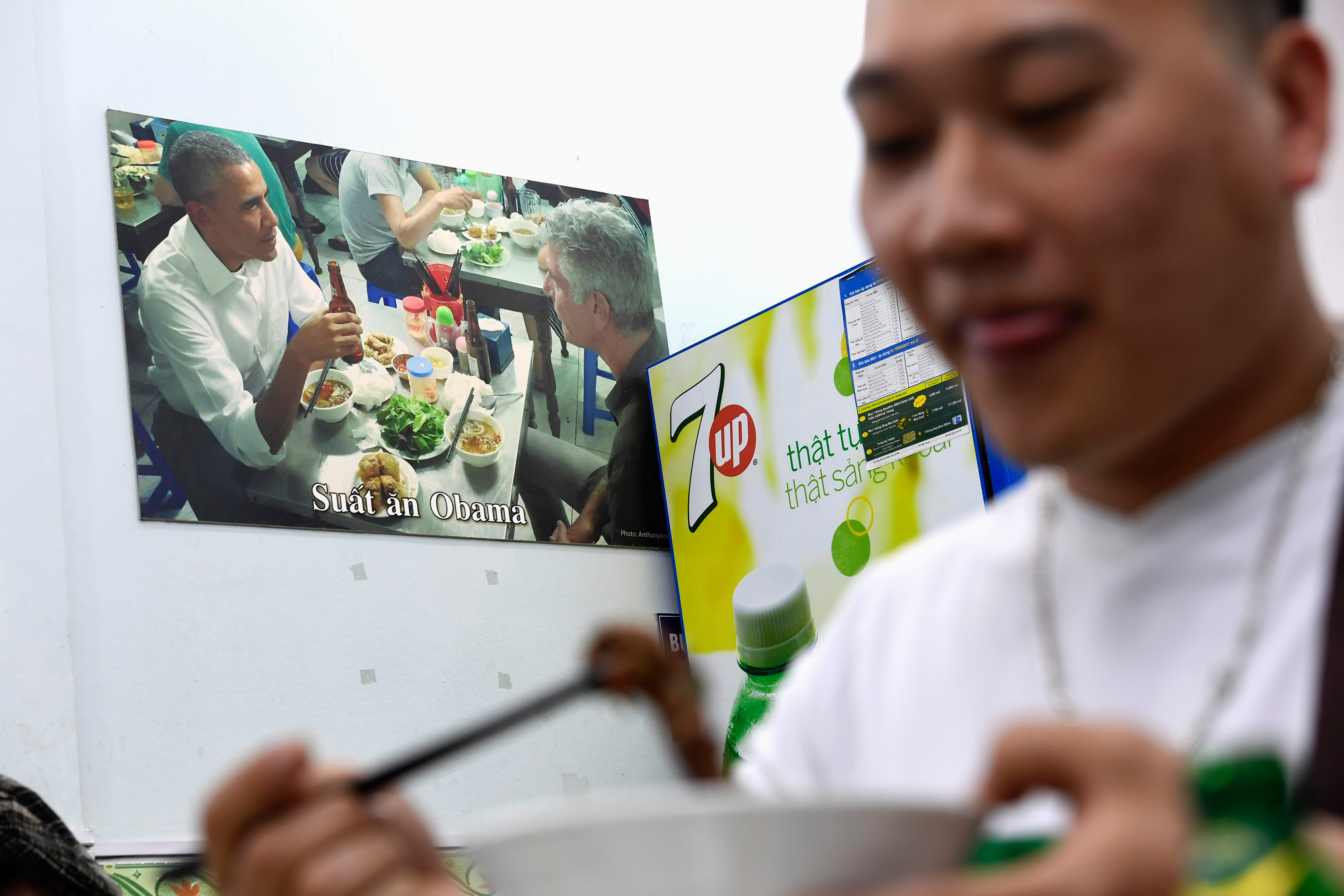 In this photograph taken on March 20, 2018, a customer enjoys a meal at Bun Cha Huong Lien restaurant, now dubbed "bun cha Obama" with a photograph of former U.S. President Barack Obama displayed on the wall, in Hanoi's old quarter. (Nhac Nguyen—AFP/Getty Images)