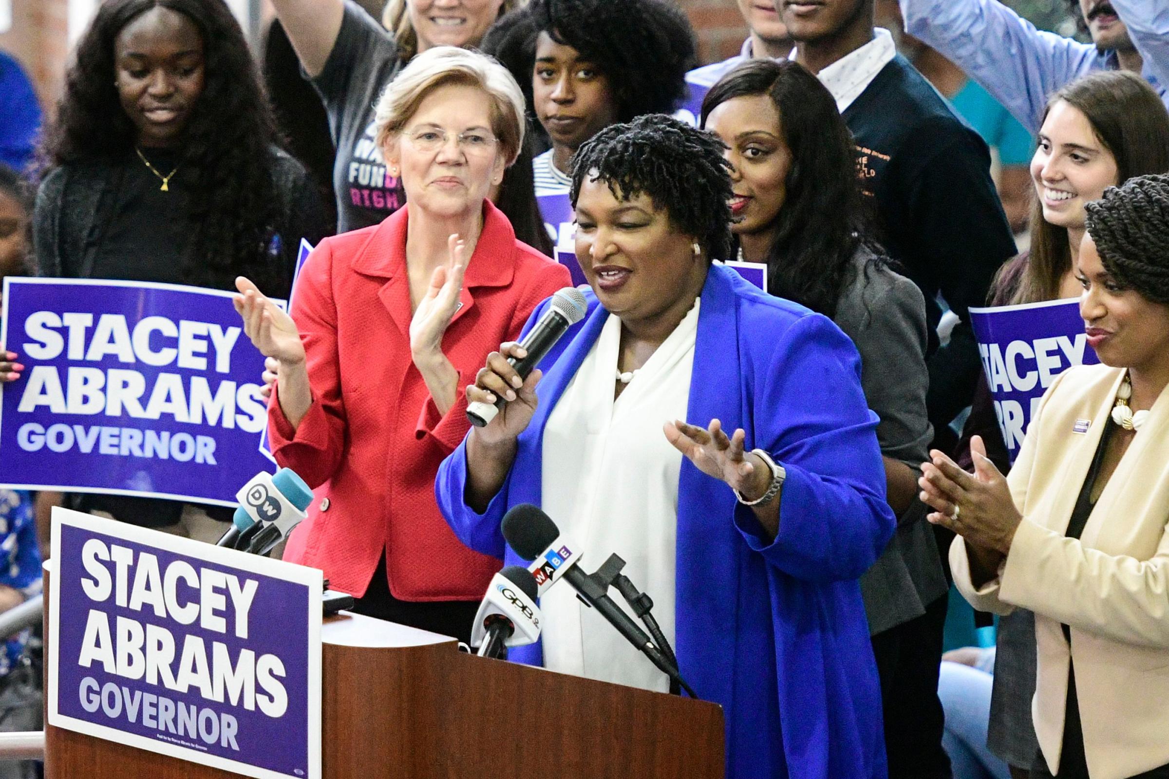 Democratic Georgia gubernatorial nominee Stacey Abrams (C) speaks to supporters while flanked by Boston City Council woman Ayanna Pressley (R) and Democratic Senator from Massachusetts Elizabeth Warren during a campaign rally in Morrow, Georgia, USA, October 9, 2018.
