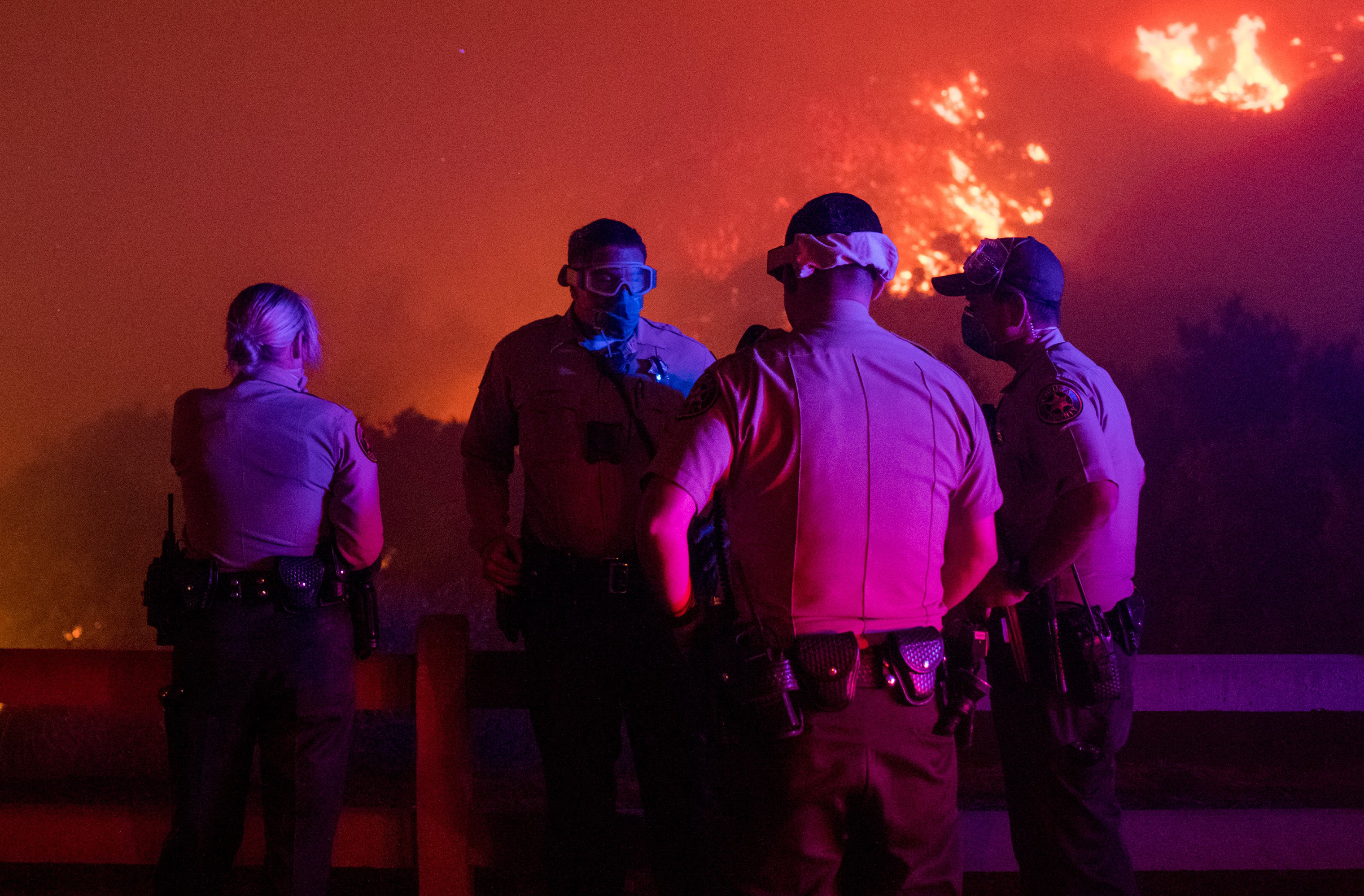 Local law enforcement standby to give mandatory evacuation orders to residents in Thousand Oaks, Calif. as the Wooolsey fire burns over 8,000 acres on Nov. 8. (Christian Monterrosa—Sipa USA)