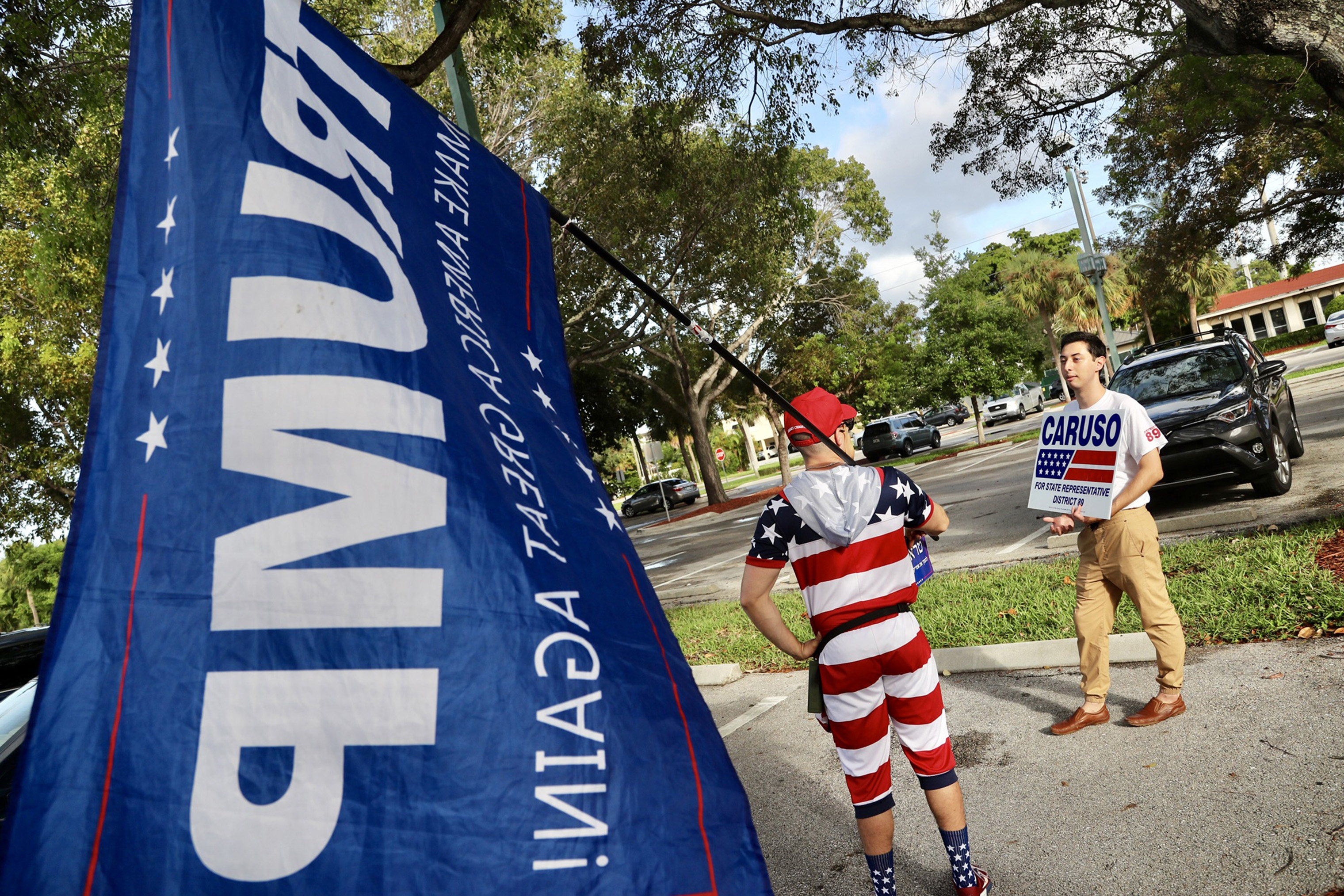 Mike Caruso campaign employee Isaac Rheinbolt, chats with a Trump supporter, who did not want to be identified, in the parking lot of the Boca Raton Community Center on Election Day. (Amy Beth Bennett—Sun Sentinel/TNS/Getty Images)