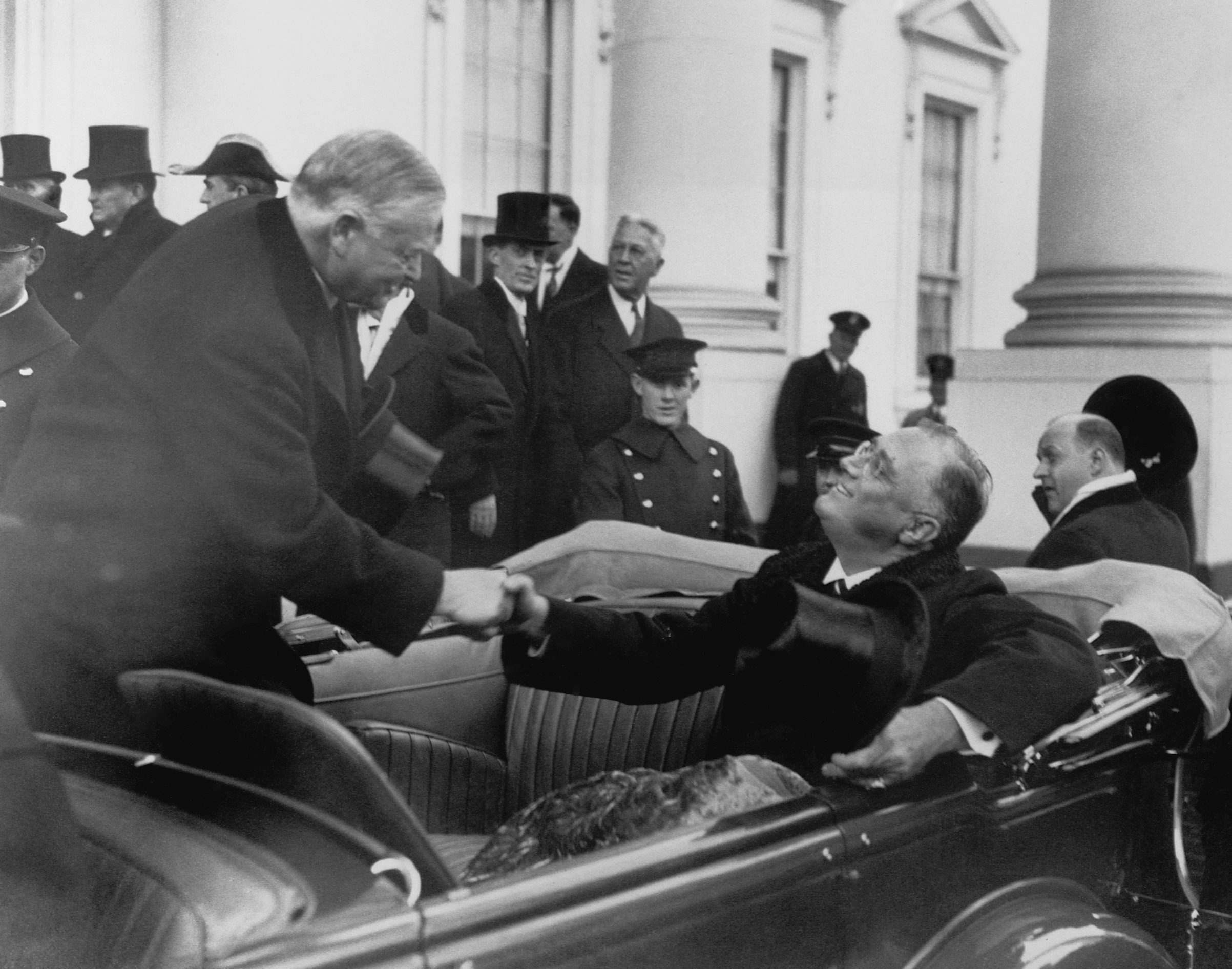 Outgoing President Herbert Hoover shakes the hand of incoming Franklin Roosevelt after Roosevelt's inauguration (Bettmann/Getty Images)