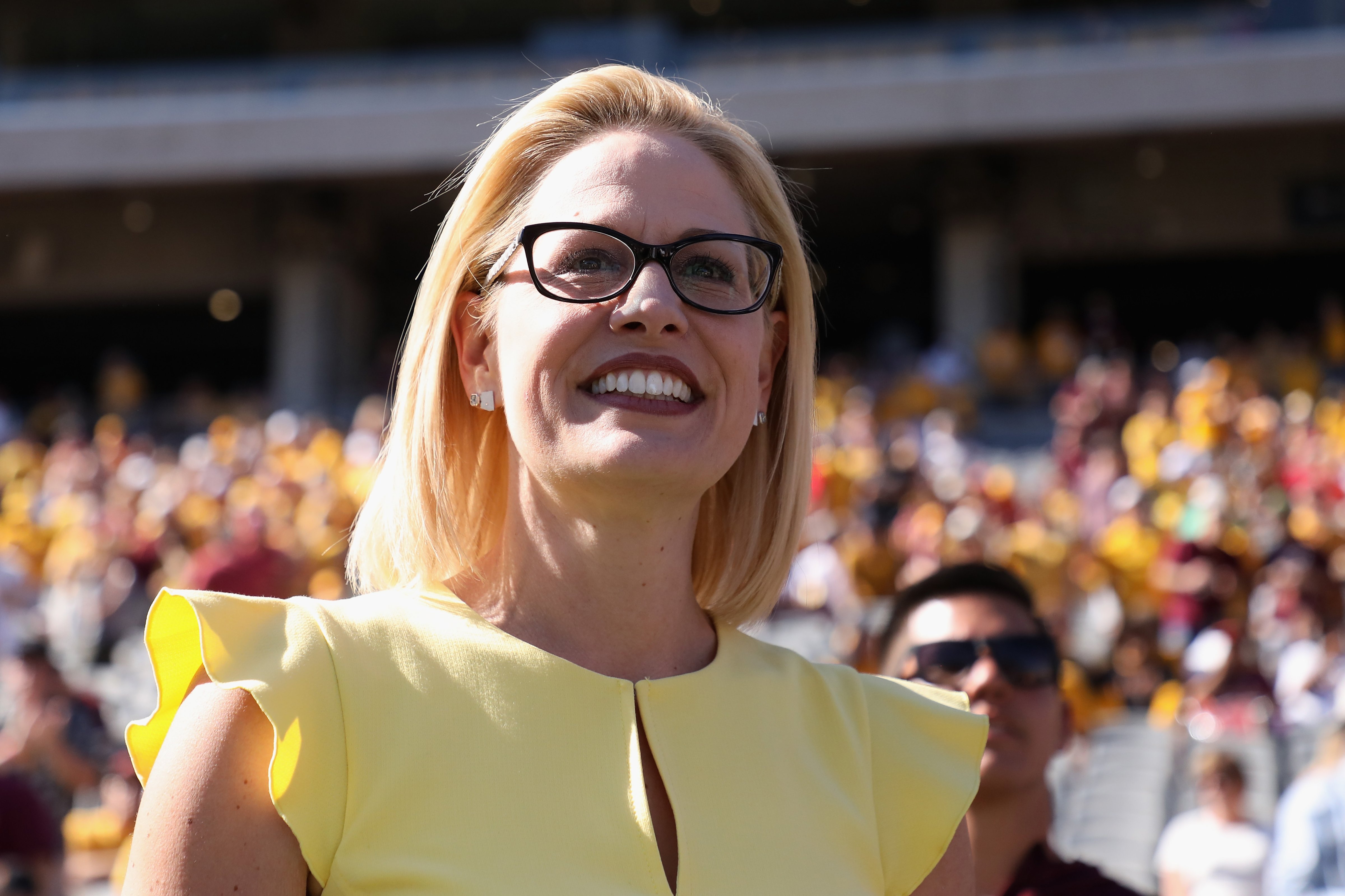 Democrat Senate candidate Kyrsten Sinema participates in the pregame coin toss before the game between the Utah Utes and the Arizona State Sun Devils on Nov. 3, 2018 in Tempe, Arizona. (Christian Petersen—Getty Images)