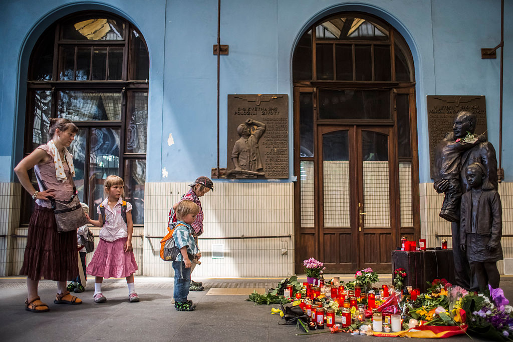 A woman and children pay respect at the statue of Sir Nicholas Winton at the main train station in Prague, Czech Republic, on July 2, 2015.. Winton saved 669 mostly Jewish children from the Nazis by organising their escape from occupied Czechoslovakia to the U.K. (Matej Divizna—Getty Images)