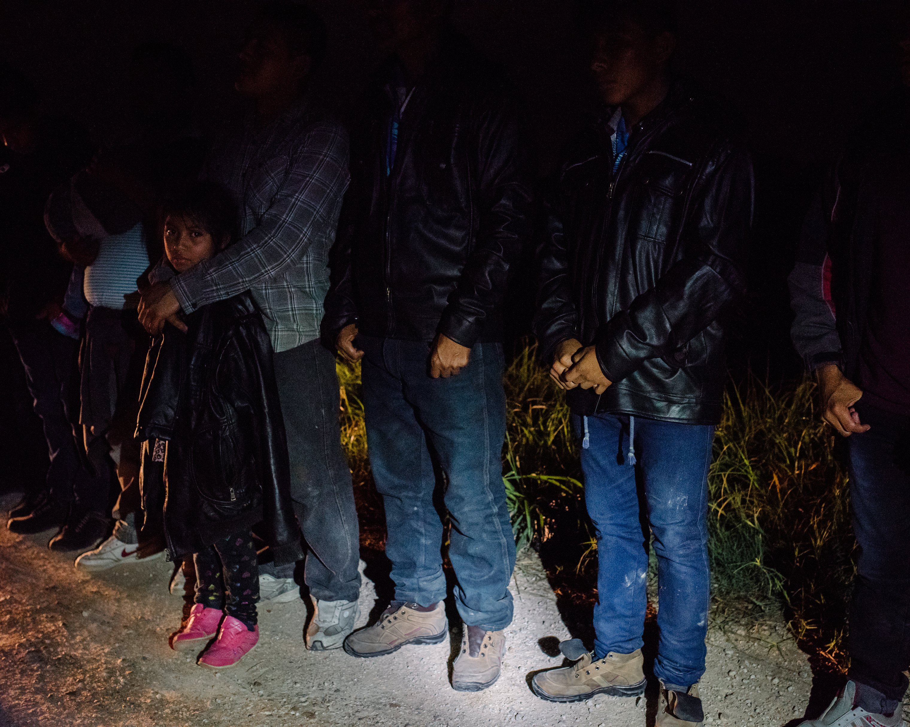 U.S. Border Patrol agents arrest a group of 43 Central American migrants, including children, on a roadside in McAllen, Texas, during a predawn patrol in late September. (John Francis Peters for TIME)